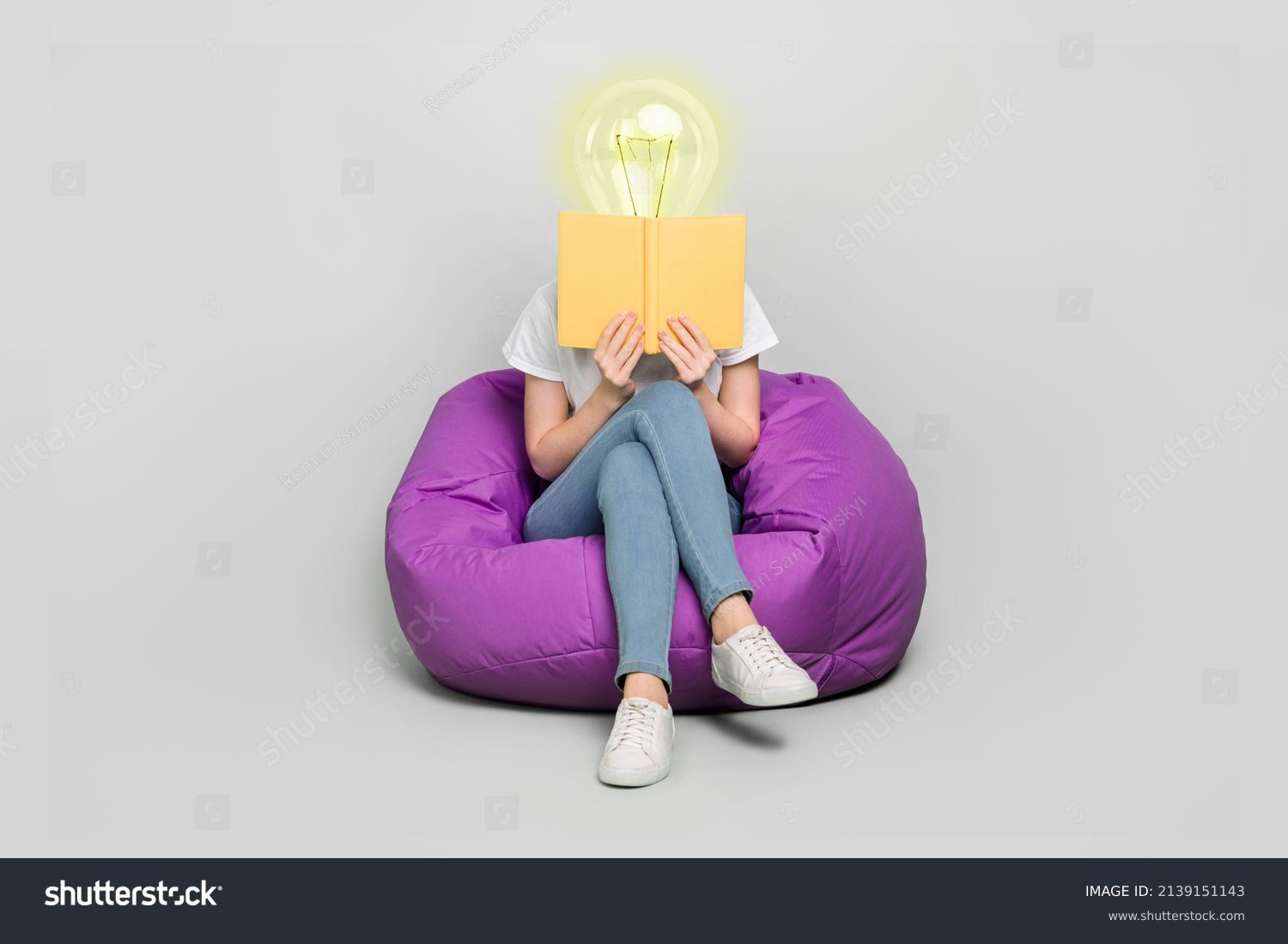 Female body of model with bright electric bulb instead head read book sit bean bag isolated on grey color background modern design learn concept #2139151143