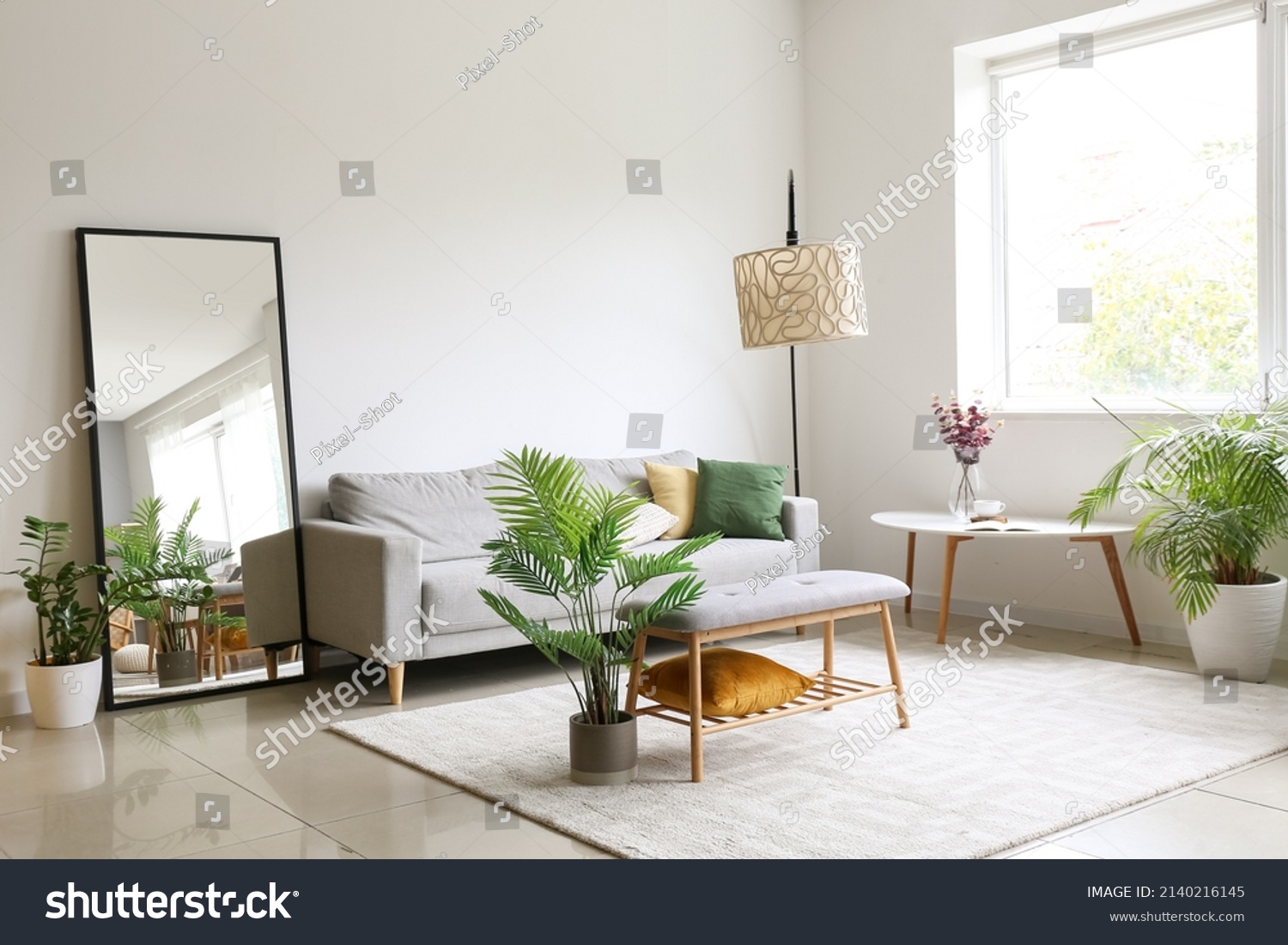 Interior of light living room with comfortable sofa, houseplants and mirror near light wall #2140216145