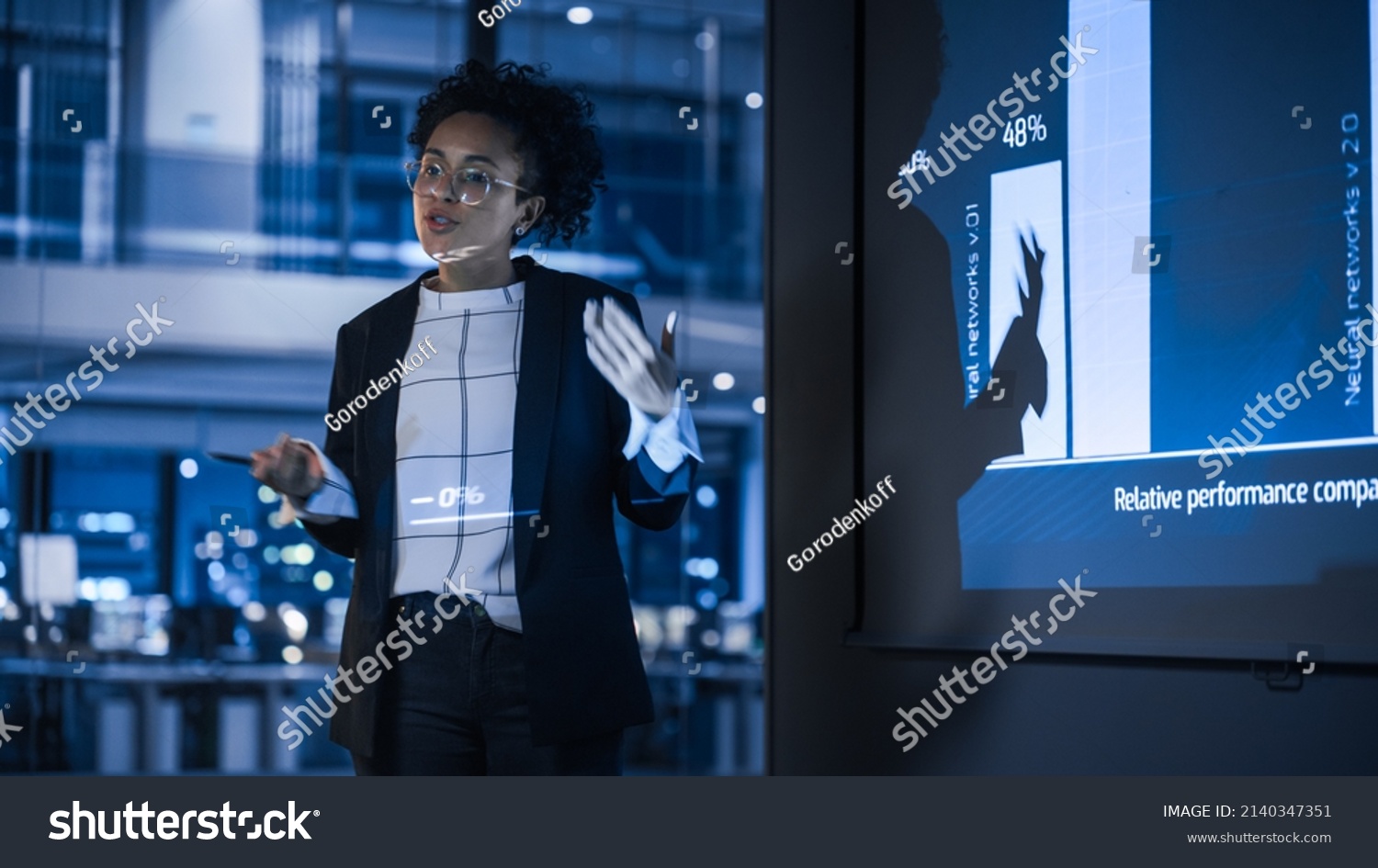 e-Business Technology Conference Presentation: Innovative Black Tech Engineer Talks about Revolutionary High-Tech Product. Projector Screen Shows Graphs, Infographics, AI, Big Data, Machine Learning #2140347351