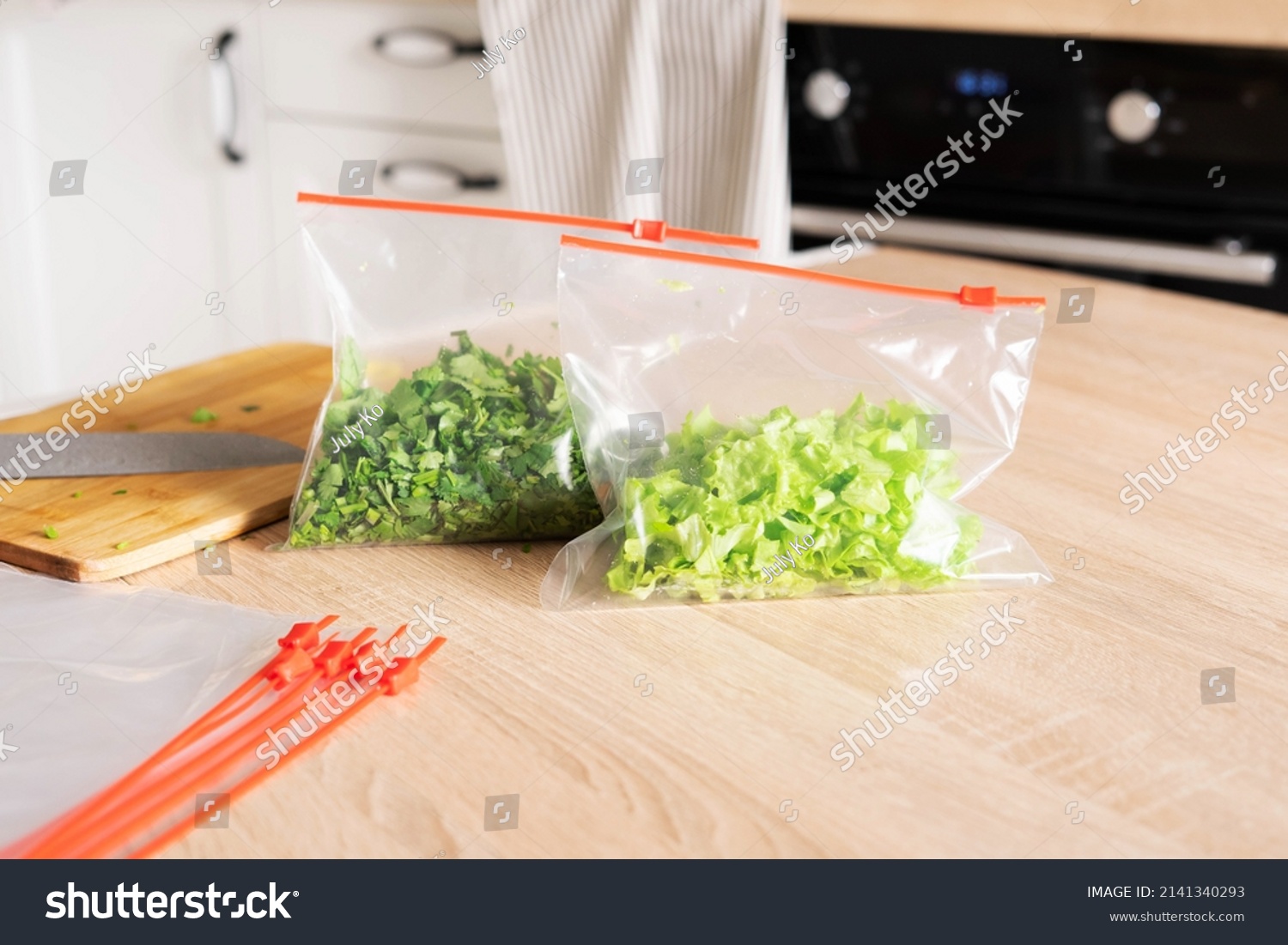 Greenery storage. Cilantro and lettuce in zip bags on the kitchen counter. #2141340293