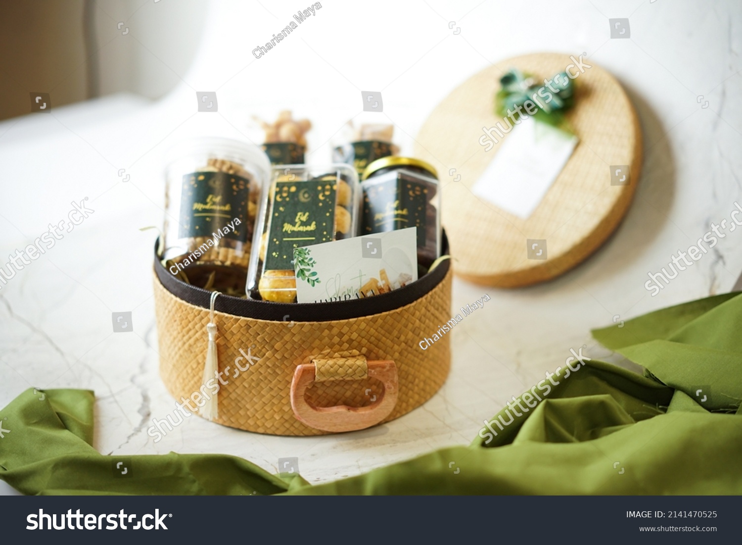 Ramadhan gift. Hampers moslem theme for celebrete the holy, bake snack, nastar, bakery, cookies, pudiing, chococips, roll cake, castangel.with greeting card and green accessories on white background #2141470525