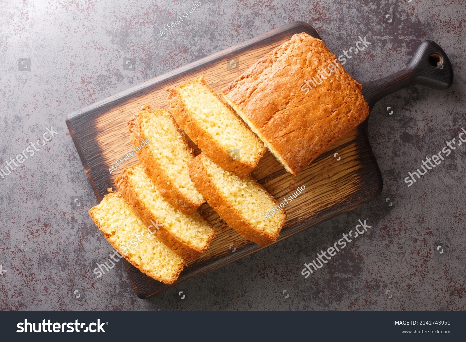 Delicious tender Madeira biscuit cake close-up on a wooden board on the table. horizontal top view from  above #2142743951
