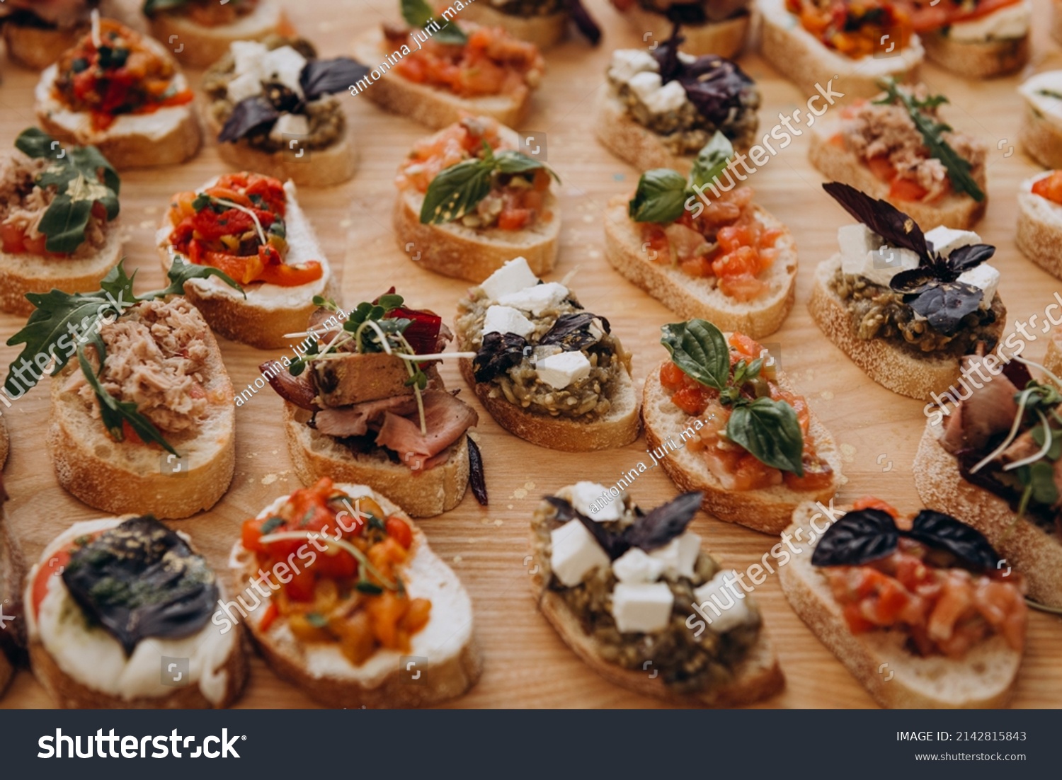 Appetizer - appetizer to wake up the appetite. Sandwiches on the table: bruschetta with butter, fish, cheese, mozzarella, tomatoes, basil #2142815843