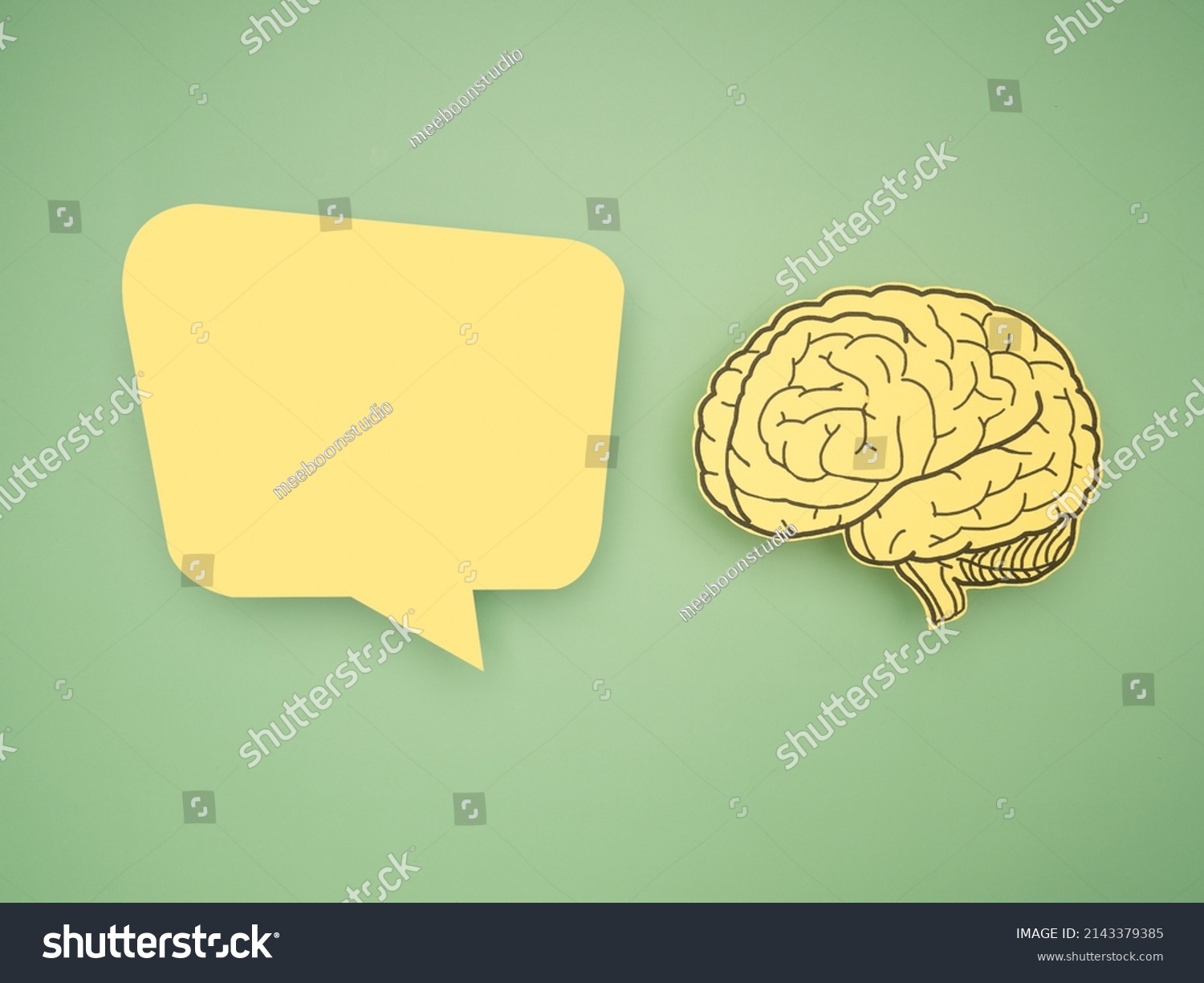 Yellow speech bubble and brain shape made from paper on a green background. Awareness of Alzheimer's, Parkinson's disease, dementia, stroke, seizure, or mental health. Neurology and Psychology care #2143379385