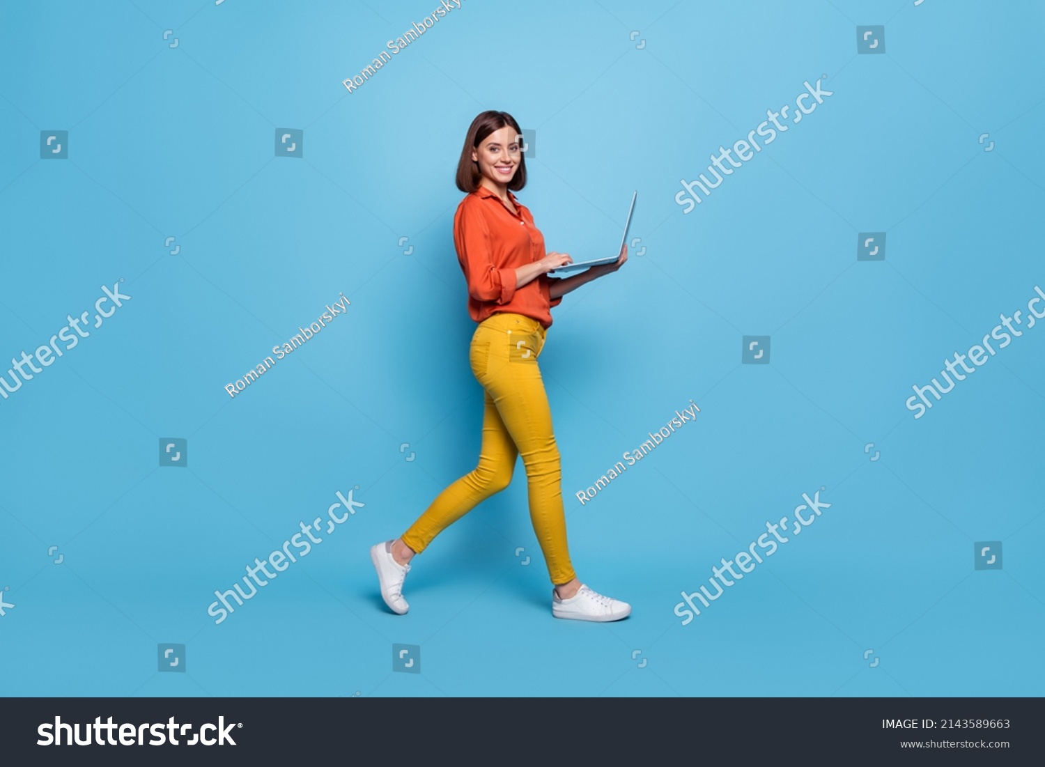 Full length body size profile side view of attractive cheery girl going using laptop isolated over bright blue color background #2143589663