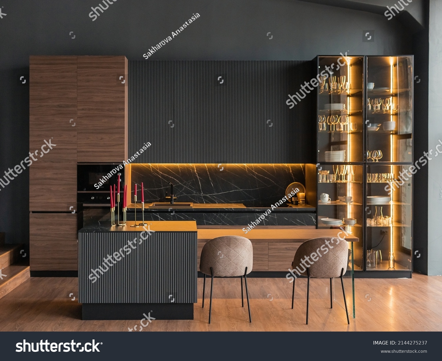 contemporary kitchen in a modern style, wooden floor, dark grey interior.  kitchen island. cabinet with glass doors and lighting for wine glasses. upholstered chairs. countertops with black cabinets #2144275237