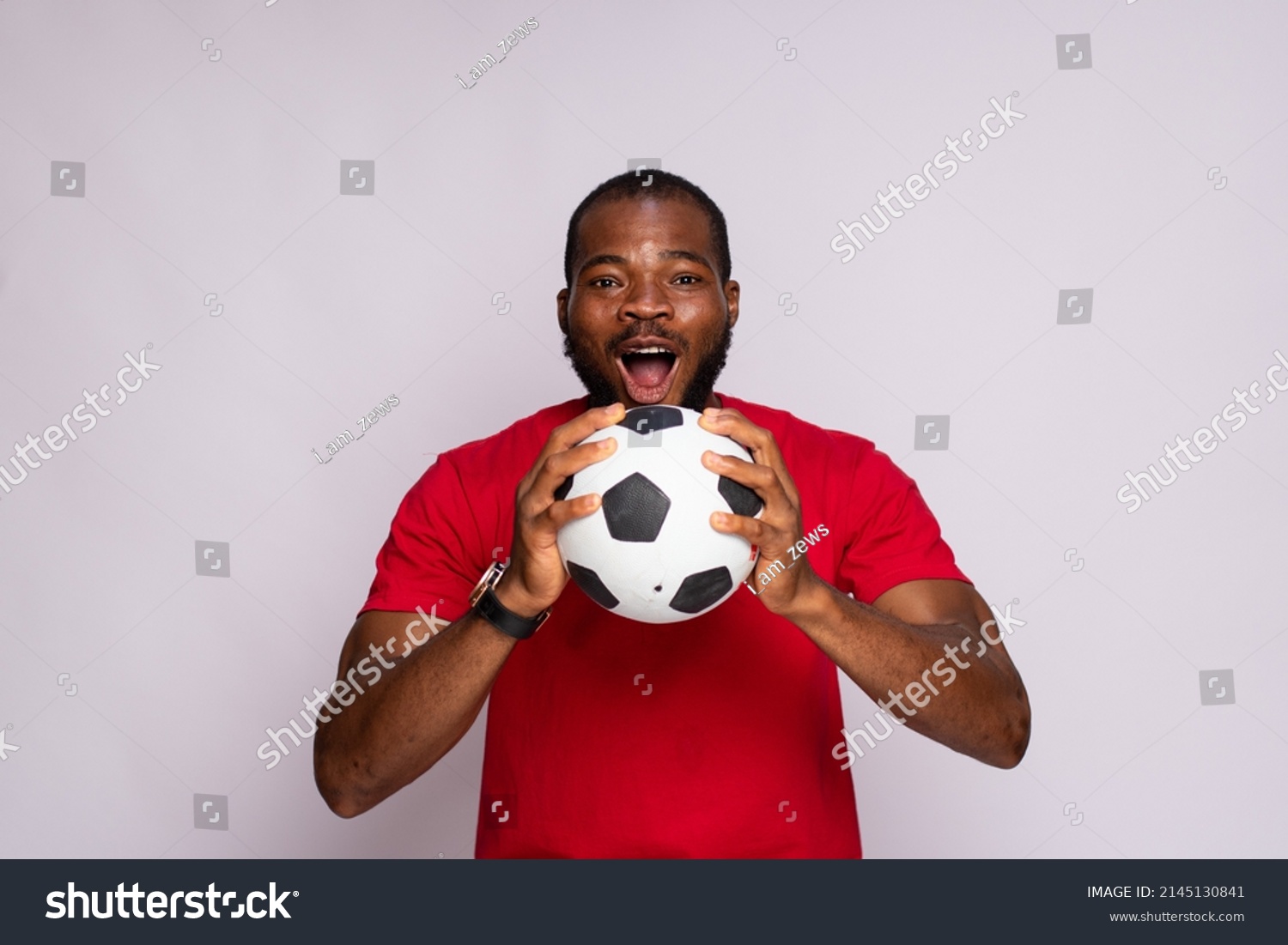 excited young black man holding a soccer ball rejoicing #2145130841