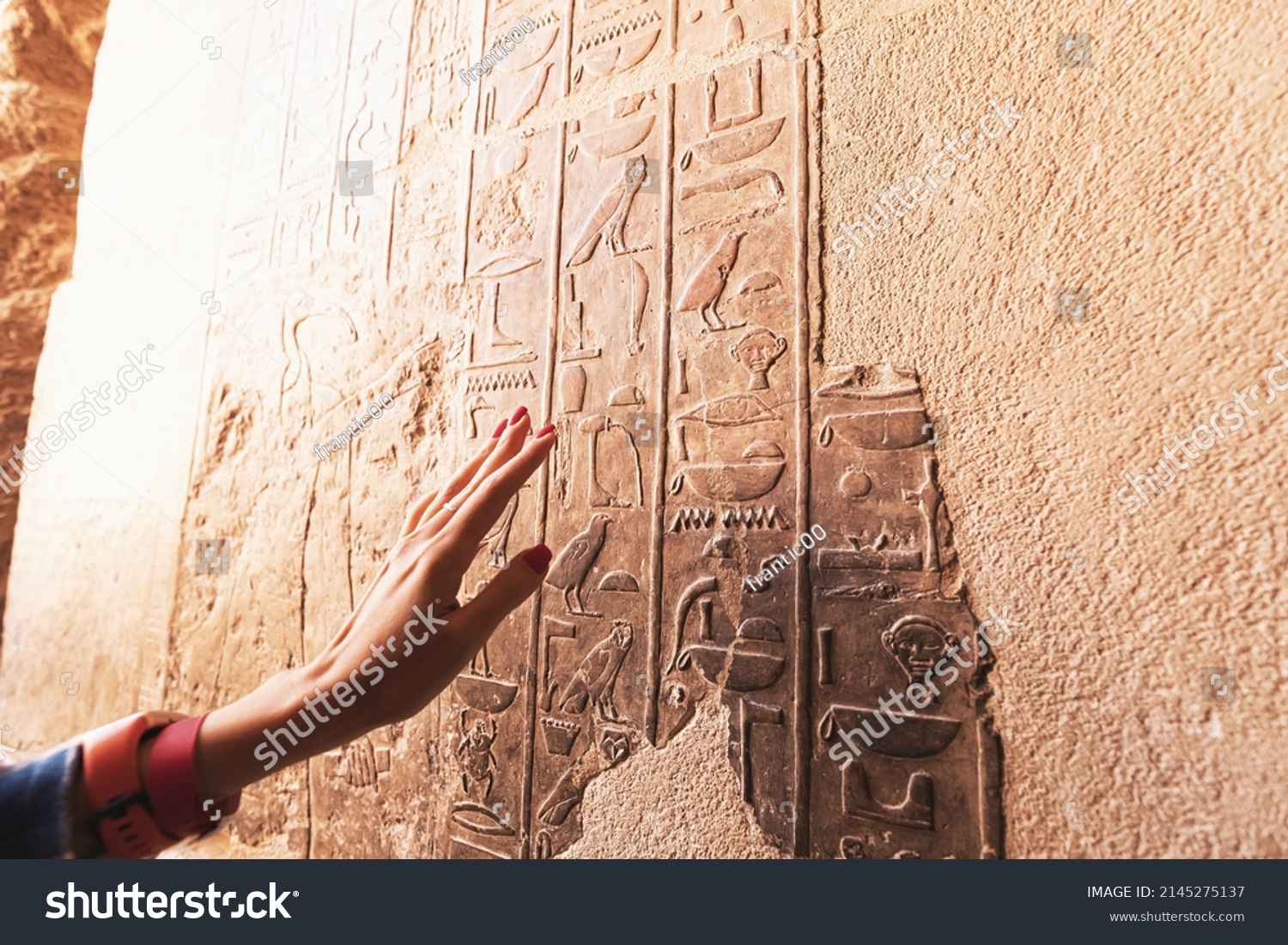 An Egyptologist or archaeologist reads and translates Egyptian hieroglyphs carved in stone #2145275137