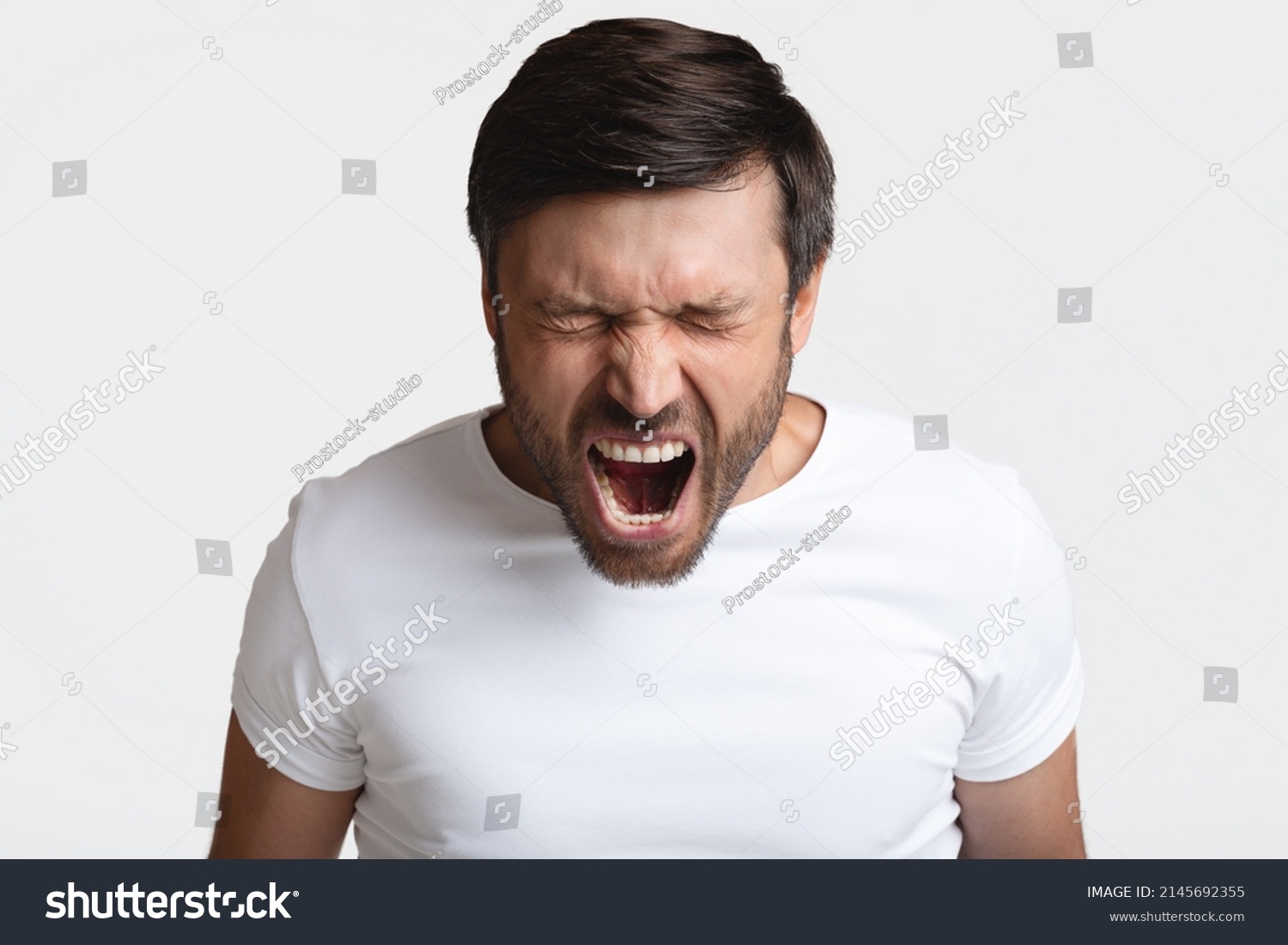 Anger. Mad Male Shouting Loudly In Anger With Eyes Closed Expressing Fury Posing Standing On White Background. Rage, Negative Emotions Concept. Studio Shot #2145692355