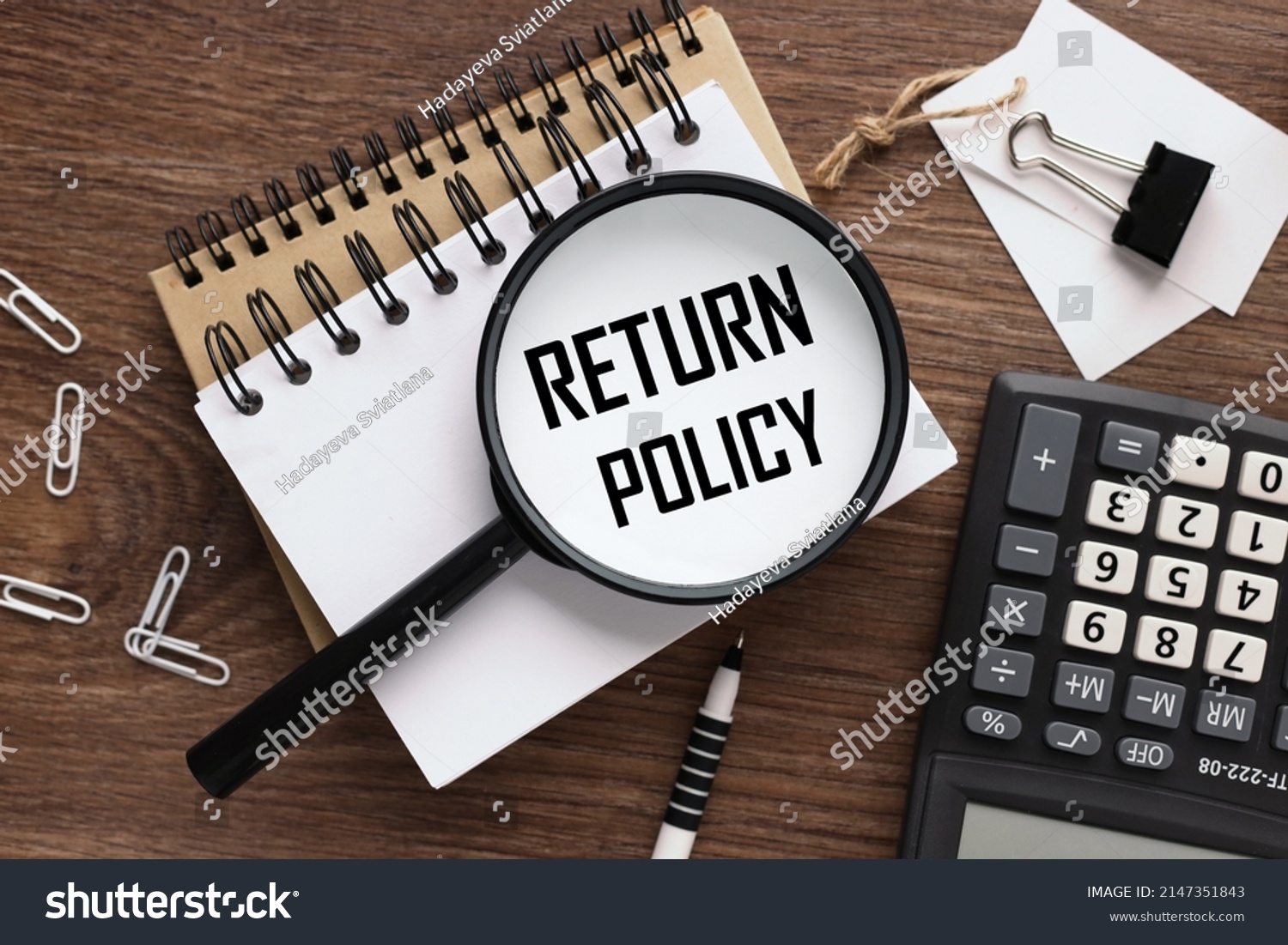 RETURN POLICY magnifying glass on a beautiful notepad. text on magnifying glass #2147351843