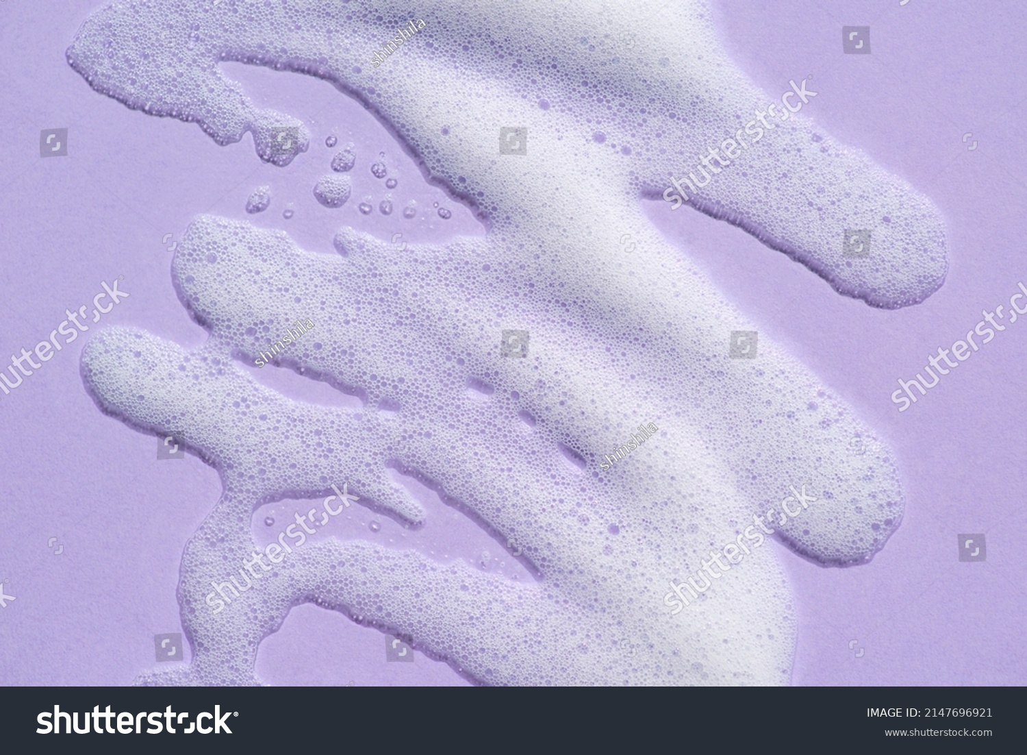 Foam swatch on a lilac background. Soapy liquid texture with bubbles. Natural sunshine and shadows. Skin care cleansing cosmetic in top view. #2147696921