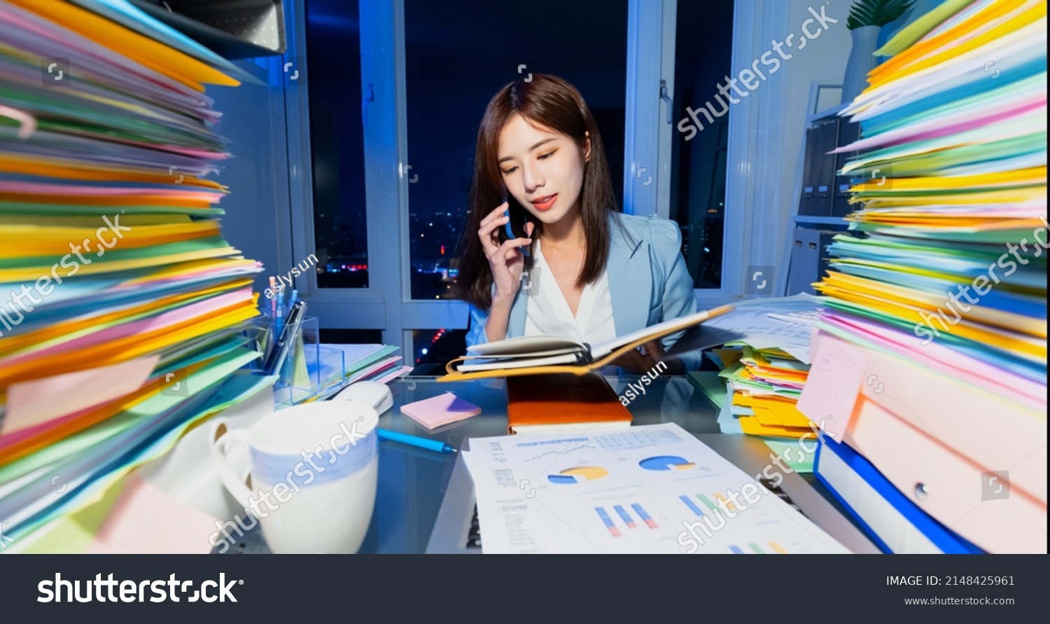 asian business woman overtime work with stack of documents and speak on phone in office at night #2148425961