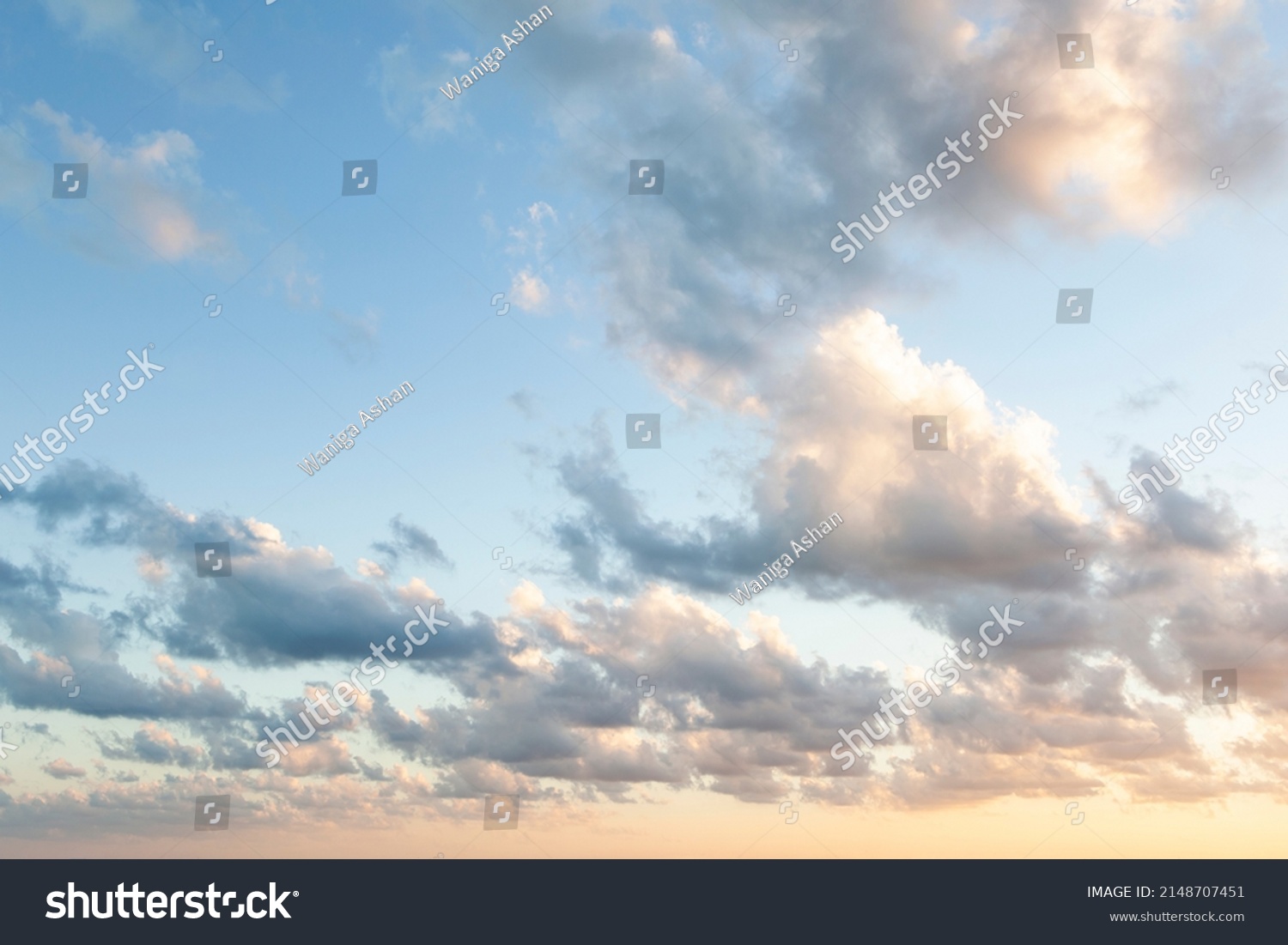 Sunset on blue sky. Blue sky with some clouds. blue sky clouds, summer skies, cloudy blue sky background. Aerial sunset view.  Evening skies with dramatic clouds. View over the clouds. #2148707451