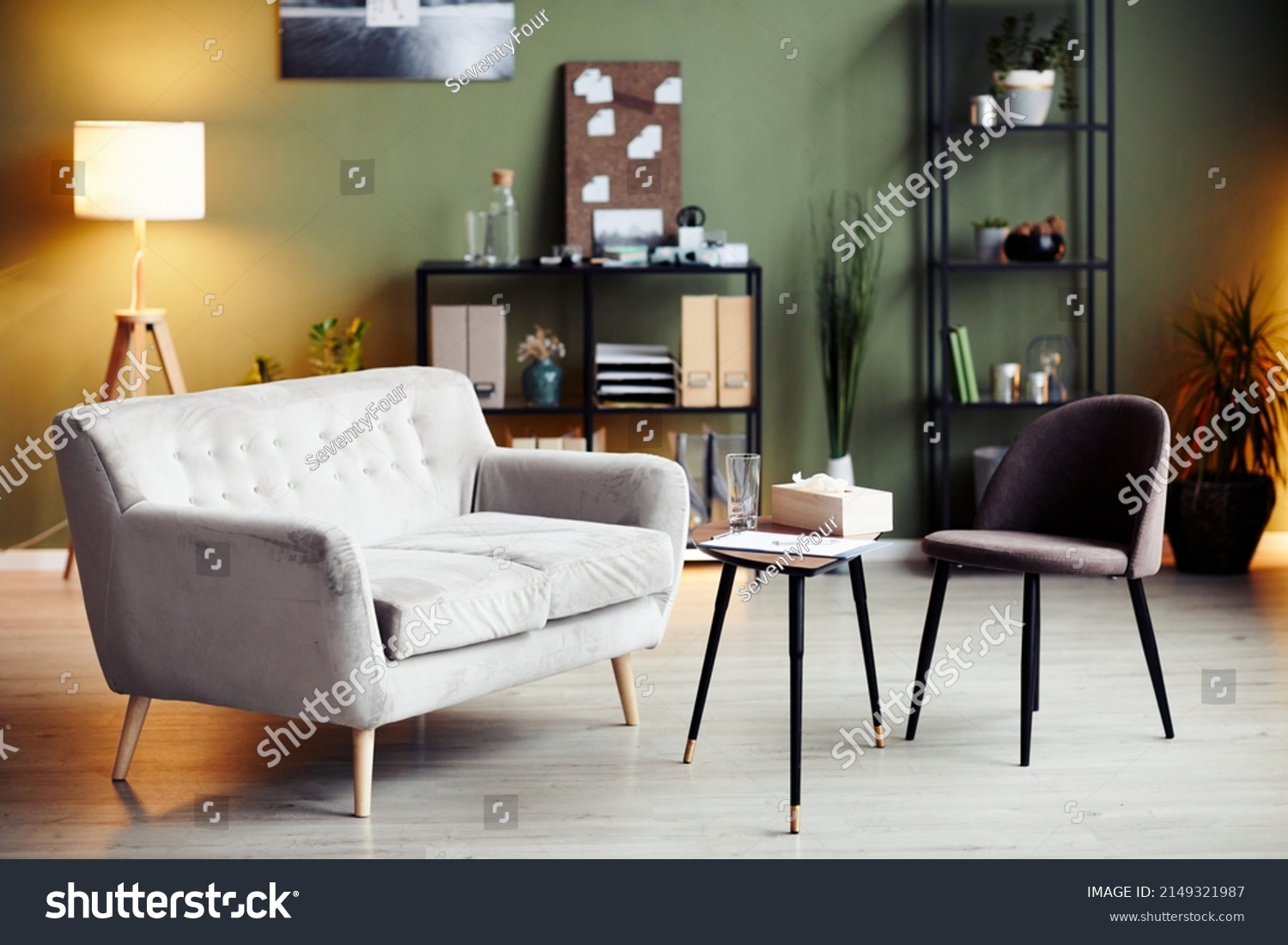 Empty chair and sofa iin front of small table in office of psychologist #2149321987