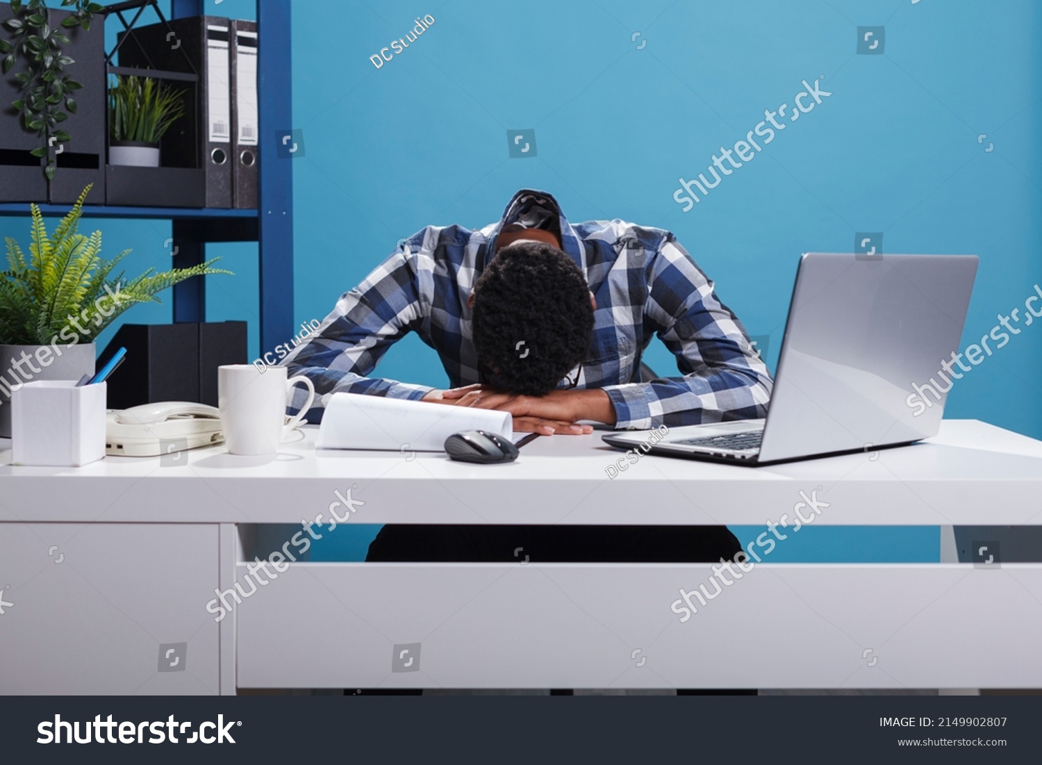 Exhausted and tired young adult office worker falling asleep on desk because of overtime work hours. Burnout fatigued company employee being sleepy and stressed because of huge work effort. #2149902807