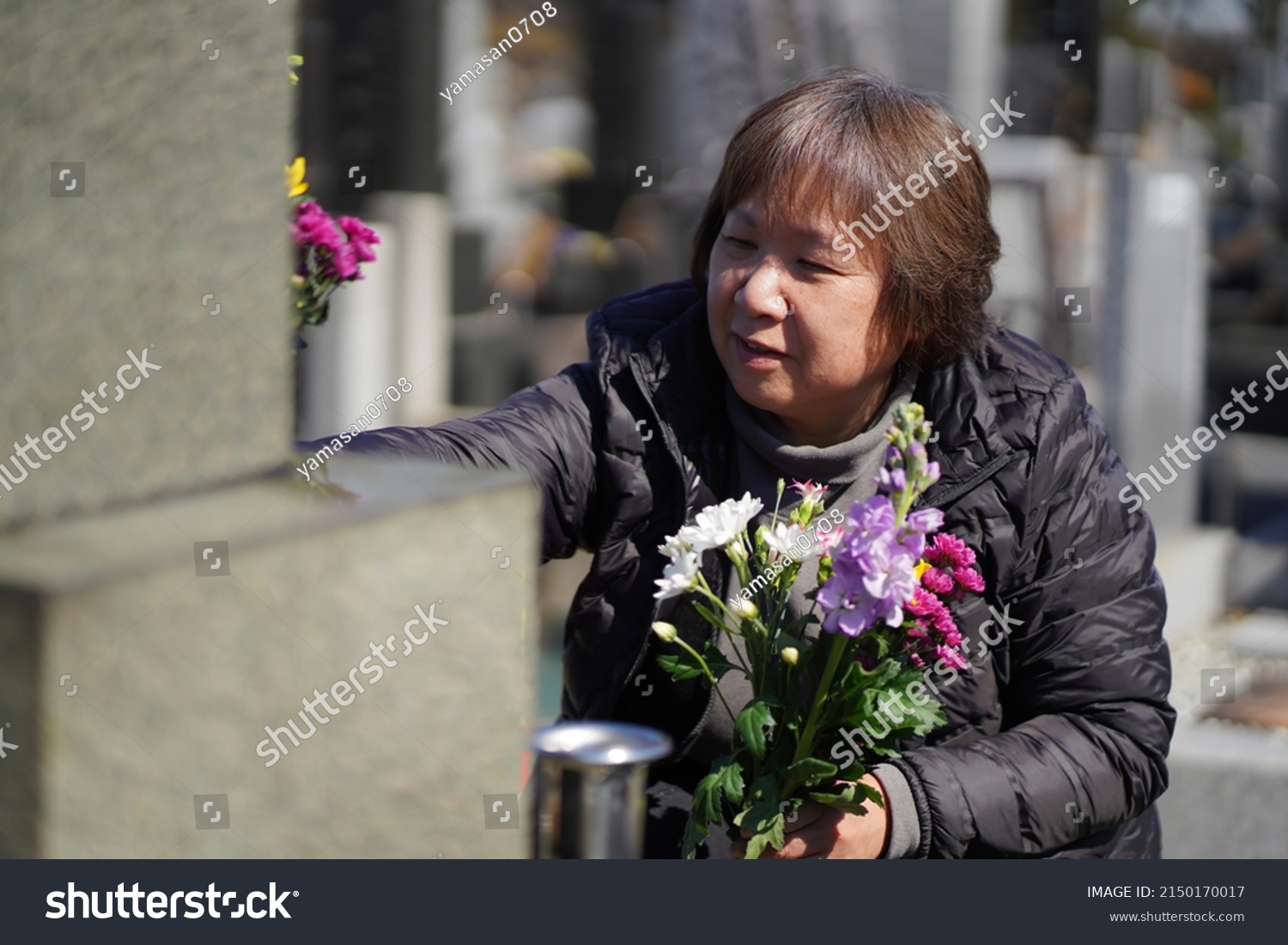 A woman visiting a grave
 #2150170017