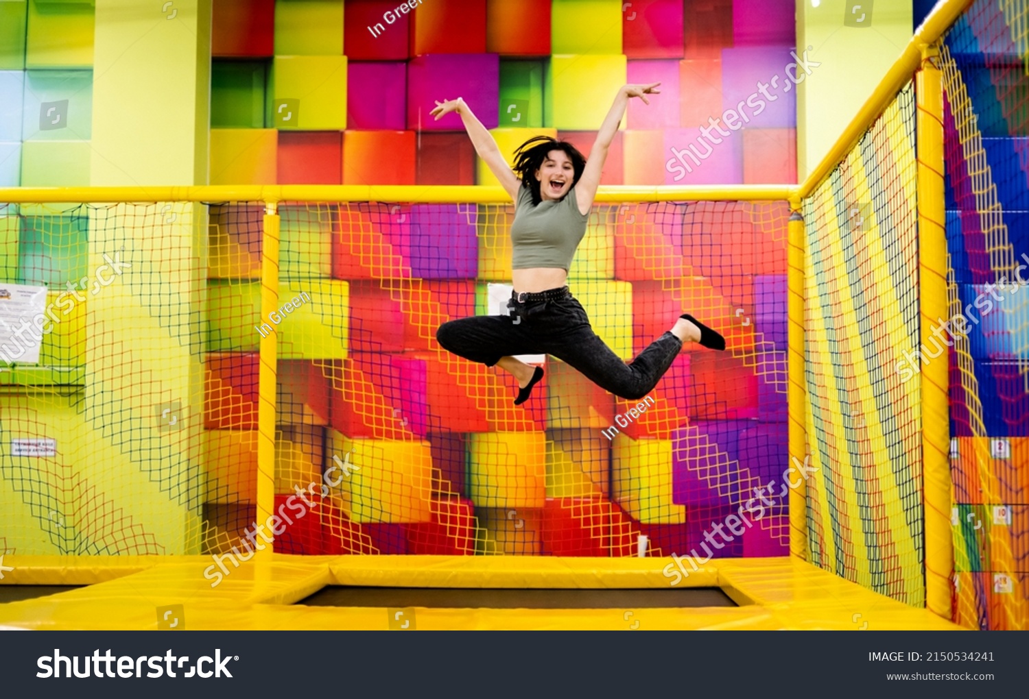 Pretty girl kid jumping on trampoline and happy at playground park. Female teenager in motion during active entertaiments #2150534241