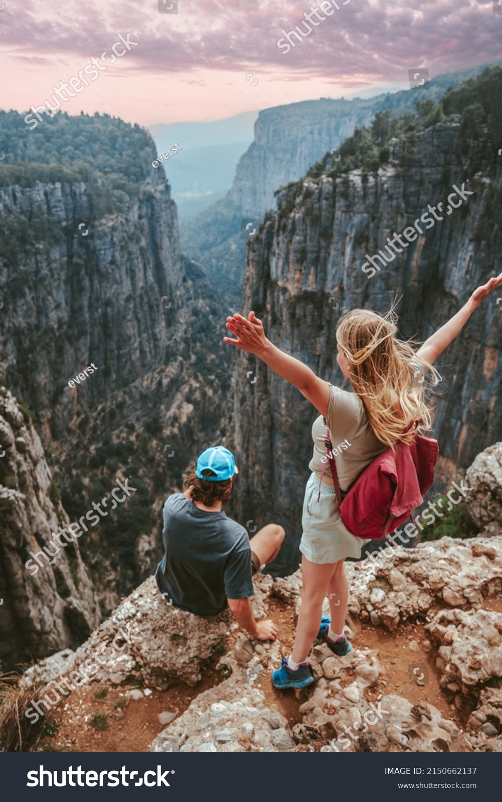Couple on cliff Tazi canyon travel hiking together healthy lifestyle active summer vacations outdoor young man and woman tourists enjoying aerial view exploring Turkey #2150662137