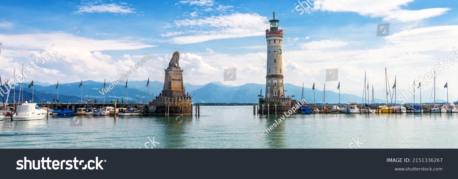 Lake Constance, panoramic view of harbor entrance in Lindau island, Germany, Europe. Landscape with old lighthouse in marina, scenic panorama of Bodensee in summer. Lindau is attraction of Bavaria. #2151336267