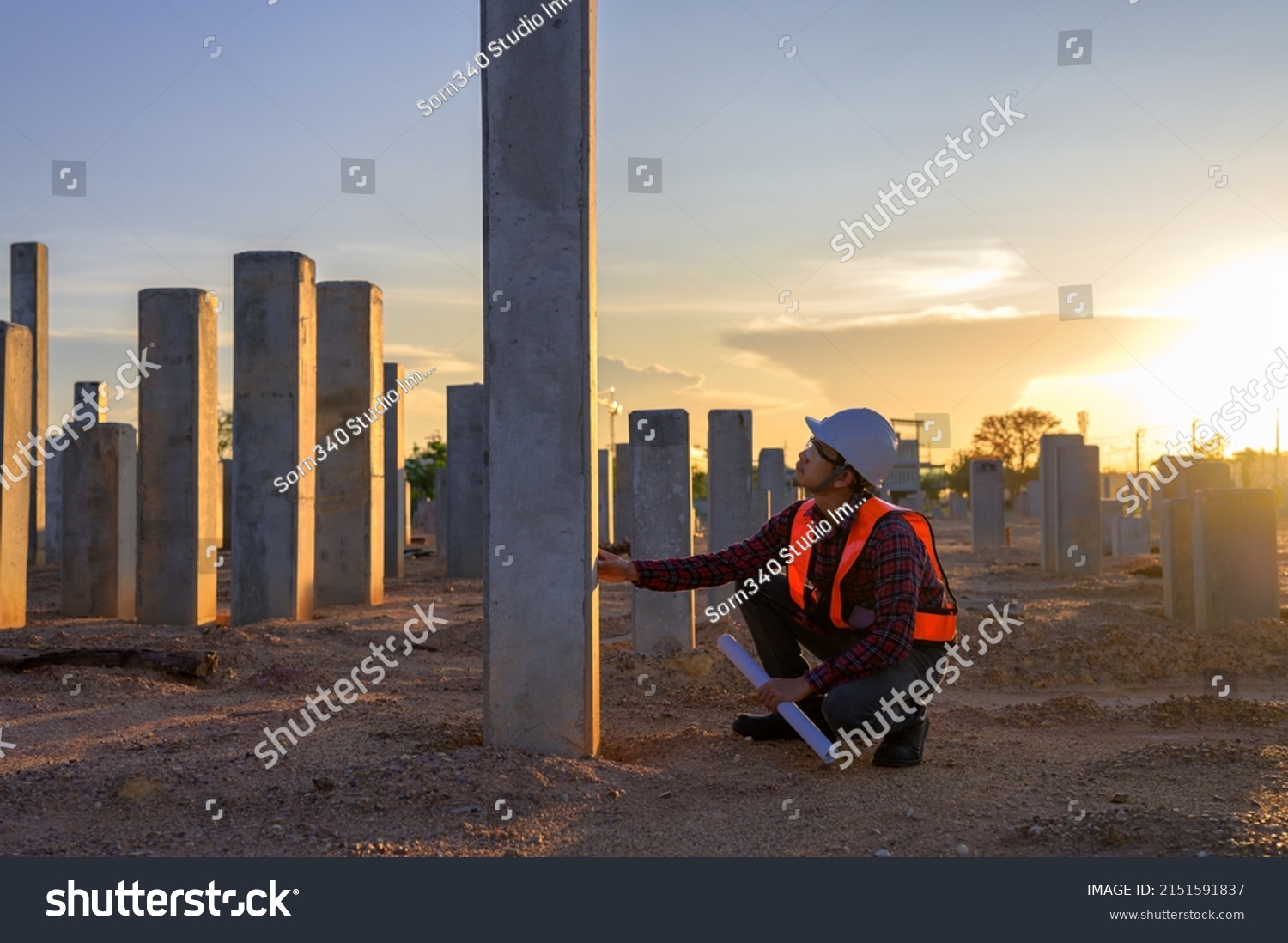 Construction engineers survey checkpoints of concrete pile,  load-bearing piles of the tall building at the construction site evening time. #2151591837