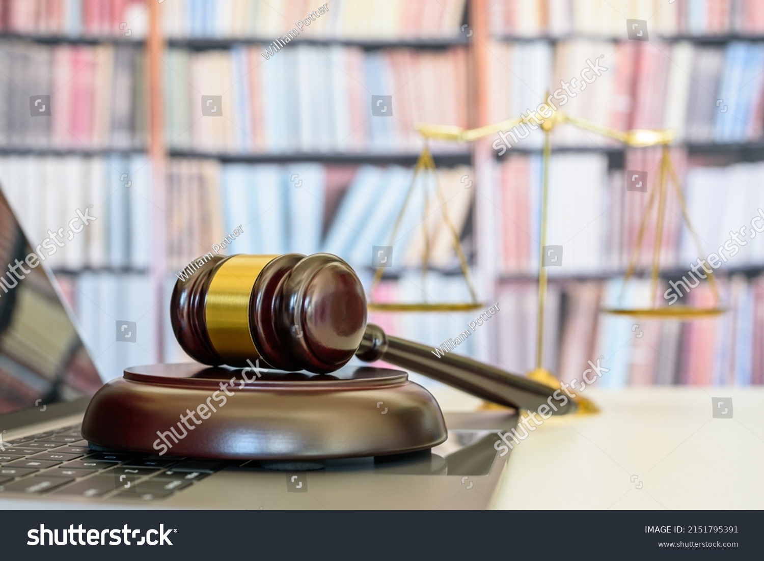 Legal office of lawyers, justice and law concept : Judge gavel or a hammer and a base used by a judge person on a desk in a courtroom with blurred weight scale of justice, bookshelf background behind. #2151795391