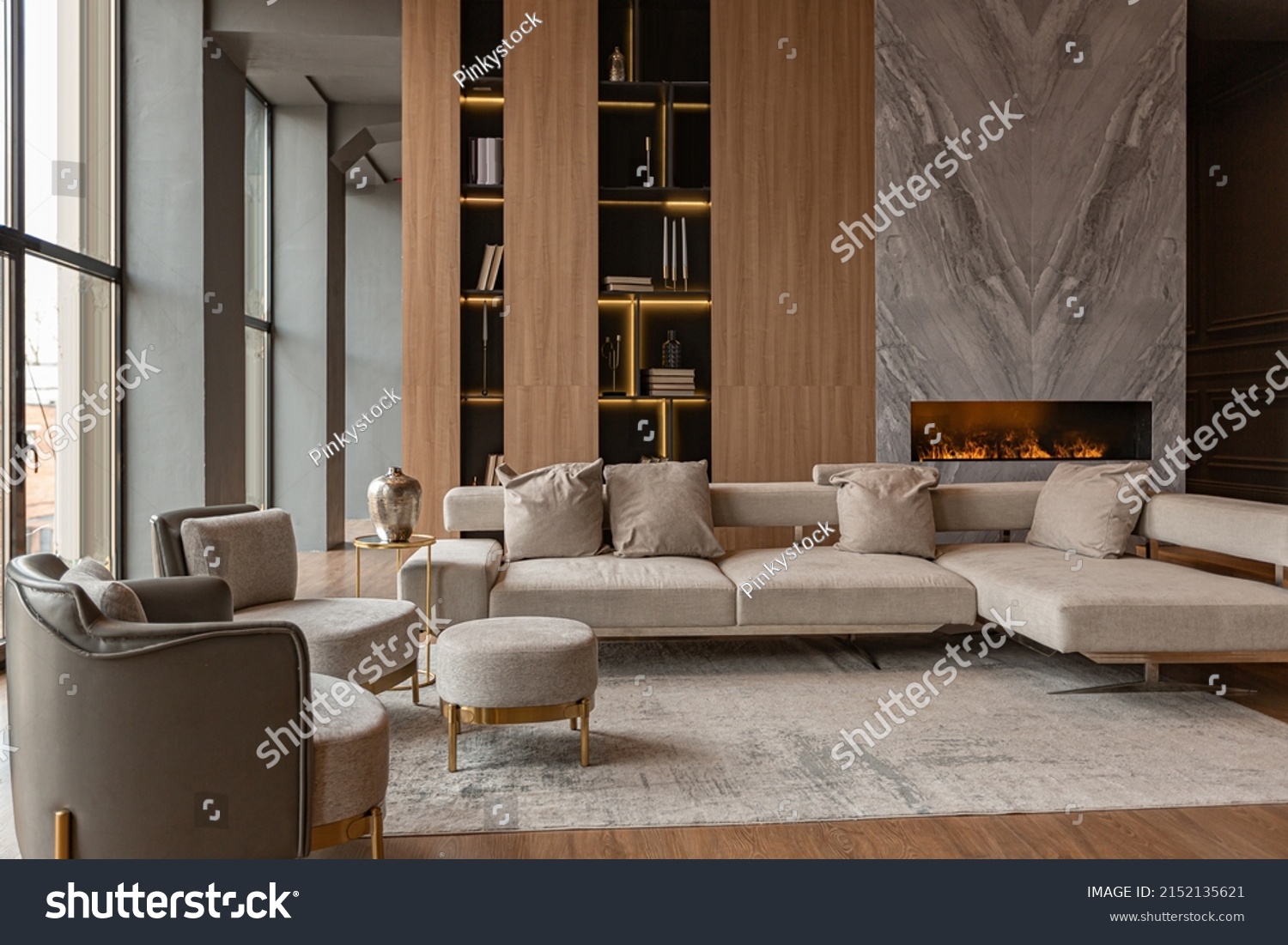 living room, marble wall fireplace and stylish bookcase to the ceiling in a chic expensive interior of a luxurious country house with a modern design with wood and led light, gray furniturу #2152135621