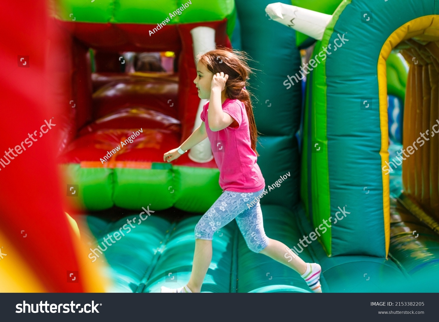 A cheerful child plays in an inflatable castle #2153382205