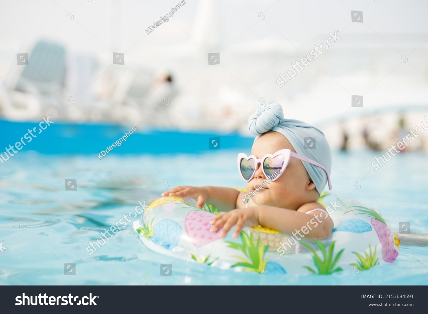 Cute funny toddler girl in colorful swimsuit and sunglasses relaxing on inflatable toy ring floating in pool have fun during summer vacation in tropical resort. Child having fun in swimming pool.  #2153694591