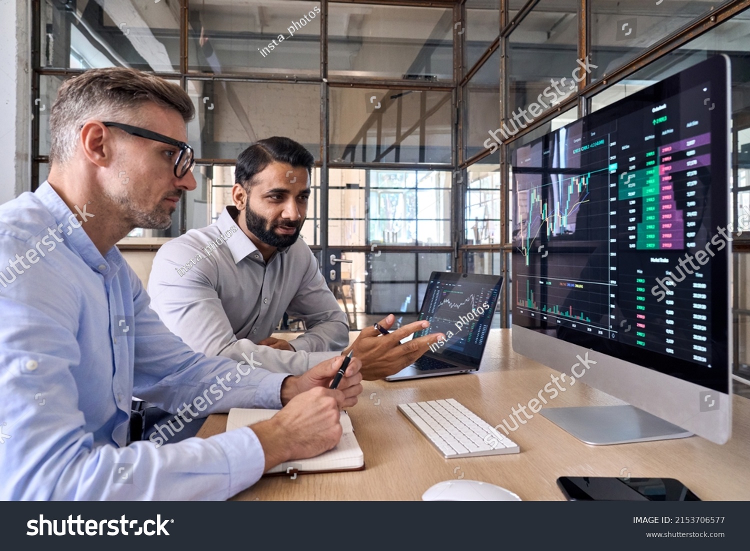 Two diverse crypto traders brokers stock exchange market investors discussing trading charts research reports growth using pc computer looking at screen analyzing invest strategy, financial risks. #2153706577