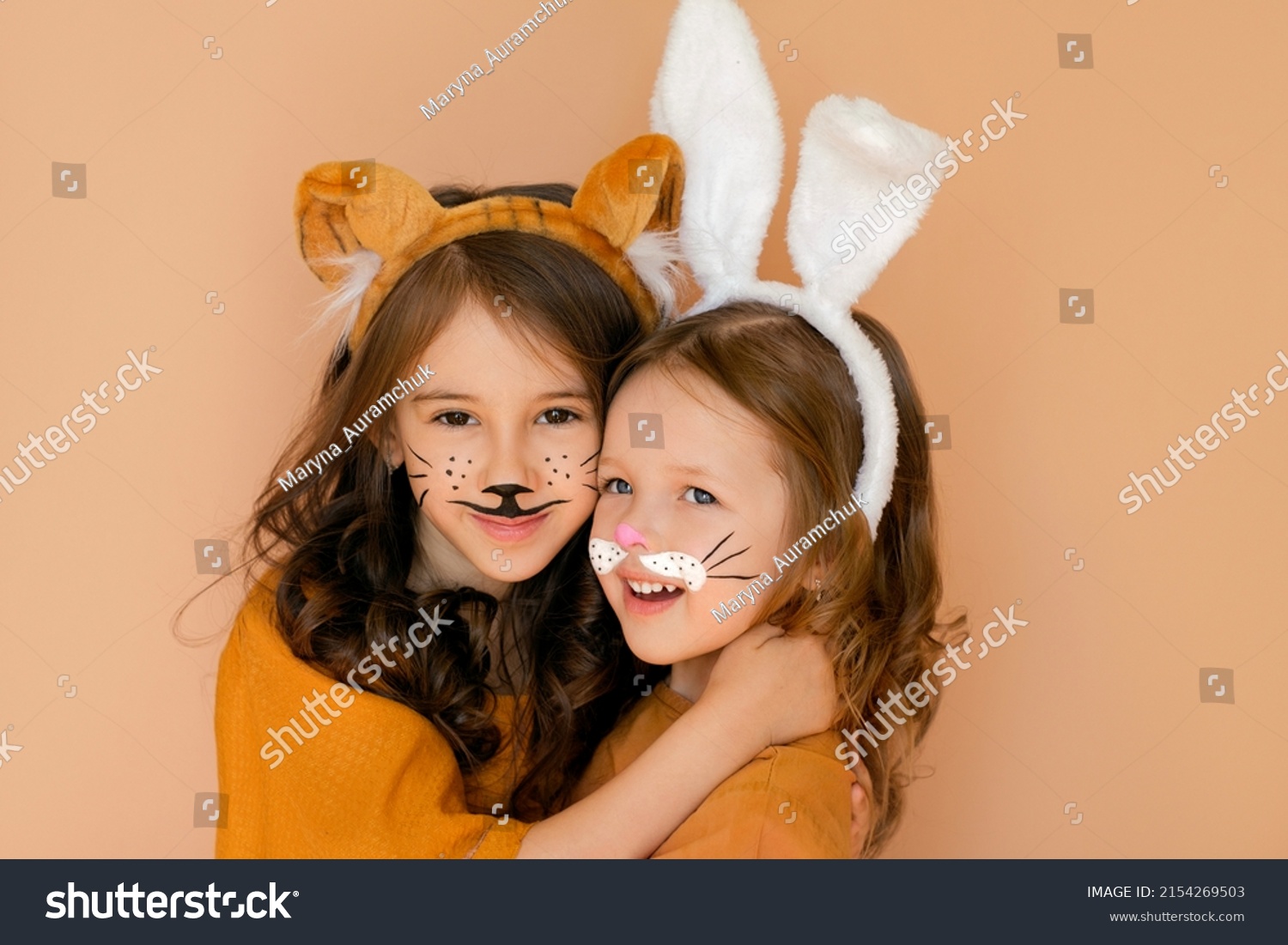 Kids with painted faces in guise of rabbit and tiger. Zodiac 2023 year according to Chinese calendar. Girl dressed up with bunny ears and makeup in anticipation new year. Symbol outgoing old year 2022 #2154269503