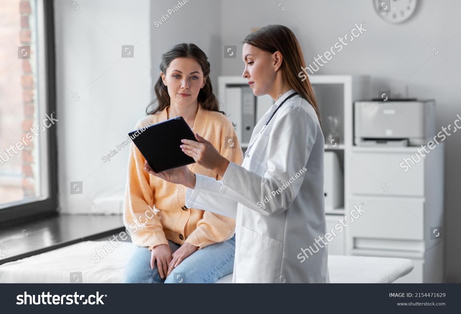 medicine, healthcare and people concept - female doctor with tablet pc computer talking to woman patient at hospital #2154471629