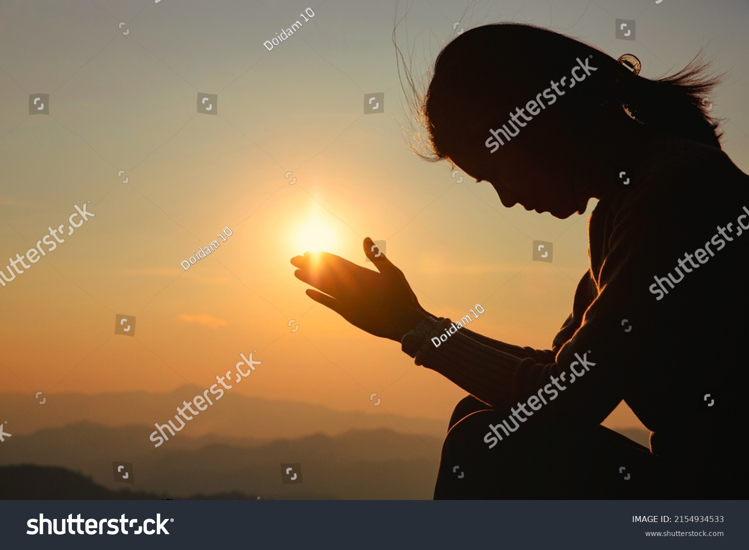 Silhouette woman on sunset background. Woman raising his hands in worship. Christian Religion concept background. #2154934533