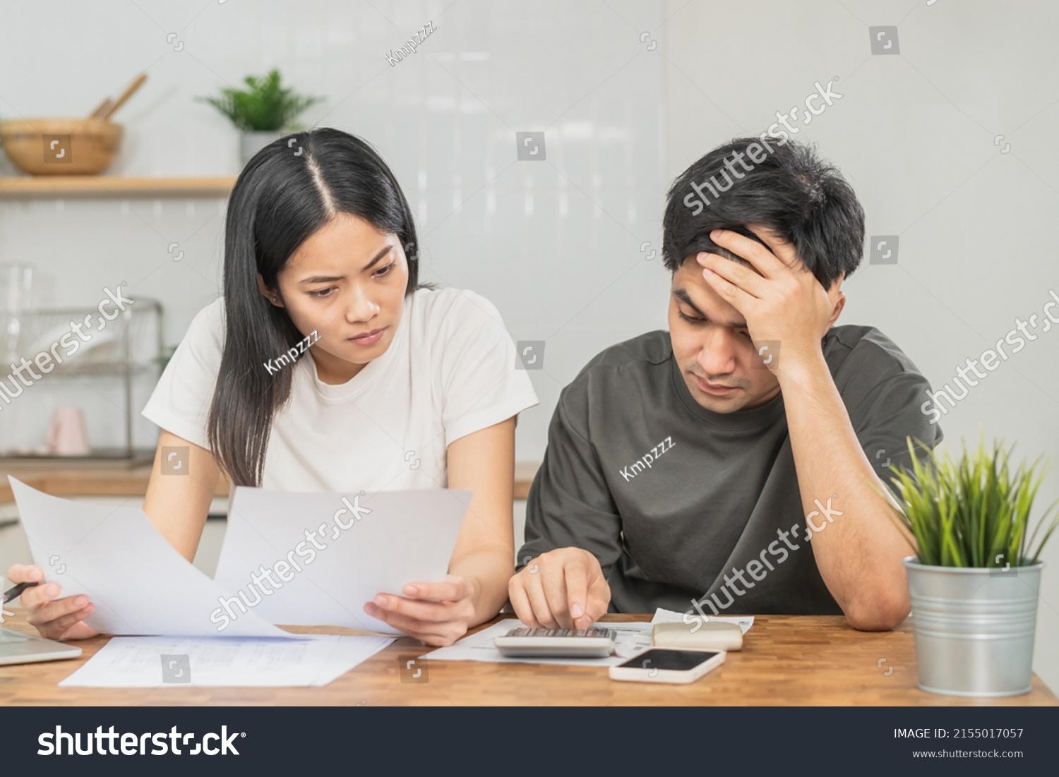 Stressed asian young couple family, wife and husband confused by calculate expense from invoice or bill, have no money to pay. Mortgage, loan causing debt, bankruptcy. Debt problems, Financial people. #2155017057