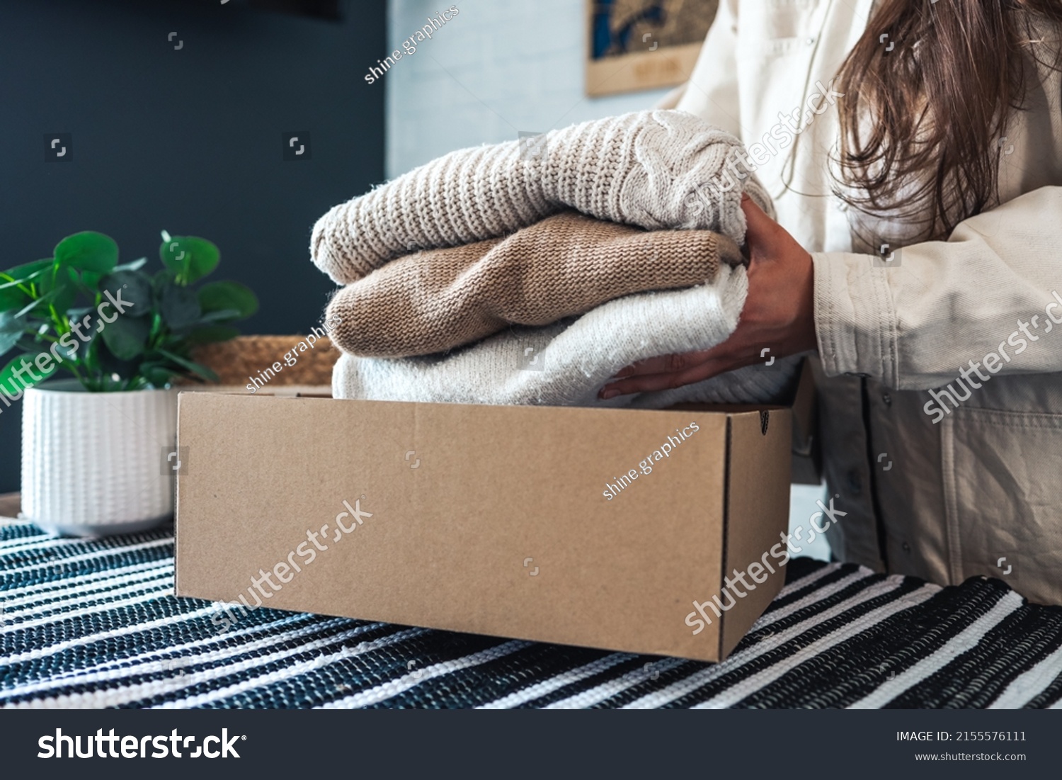 Woman holding Clothes with Donate Box In her room, Donation Concept. #2155576111