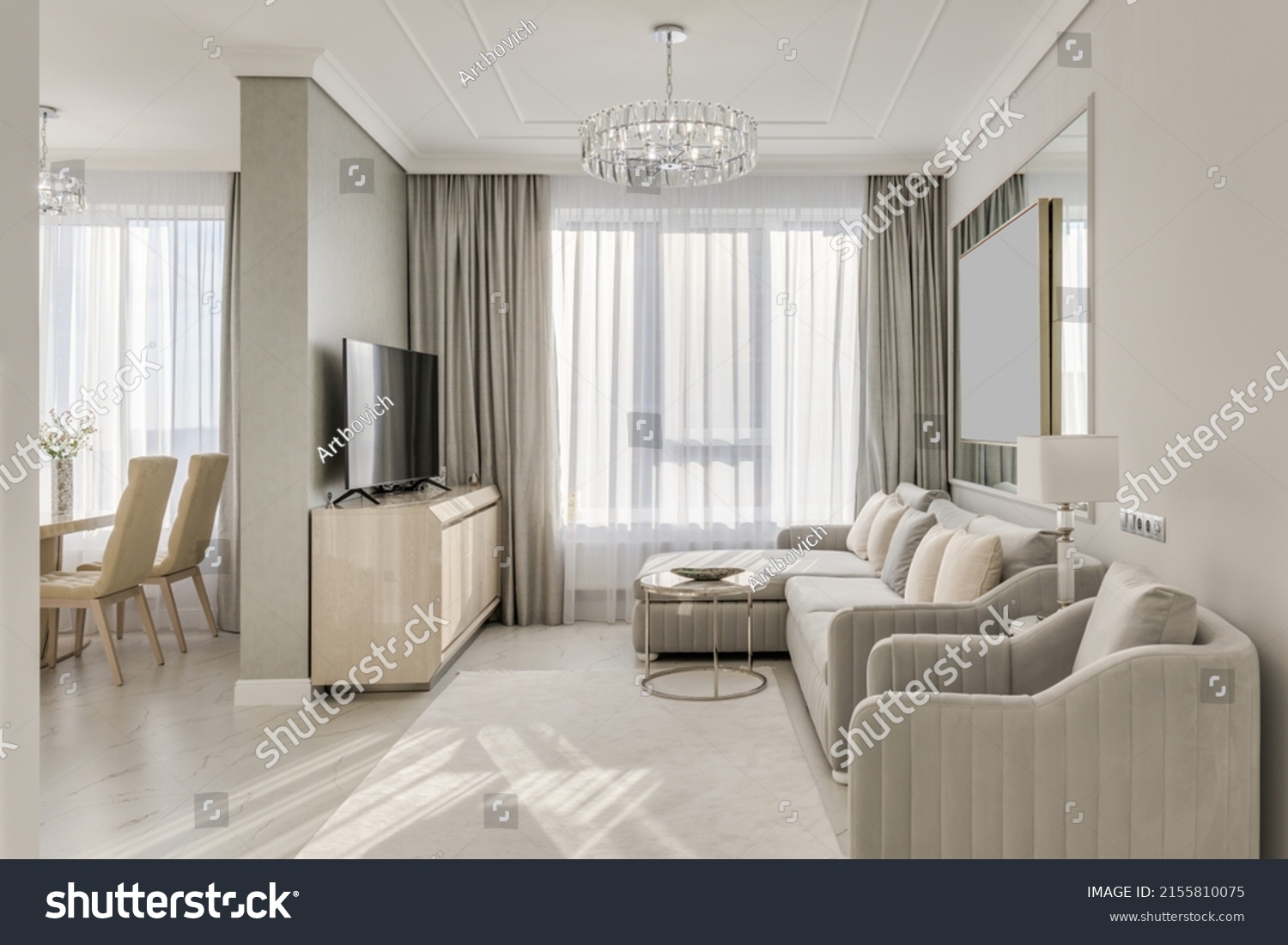 Classic interior design large bright room in neutral colors with furniture and chandelier #2155810075