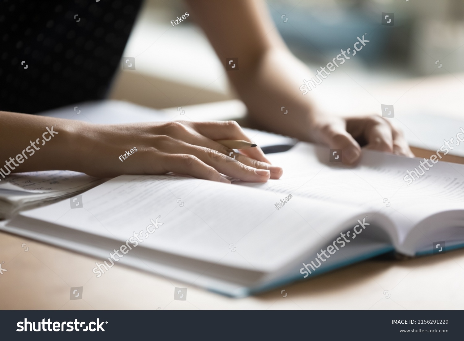 Student preparing for college test, exam, reading book, studying textbook, writing notes, making summary for class report. Learning workplace table, hands with pencil close up #2156291229