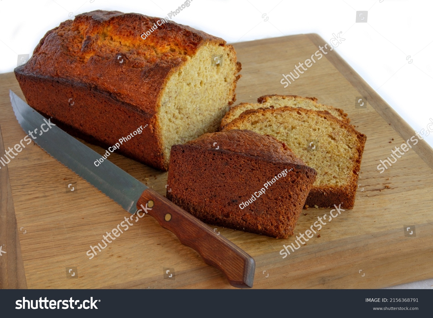 Loaf of Homemade Whole Wheat Banana Bread Loaf on Wood Breadboard with Knife #2156368791