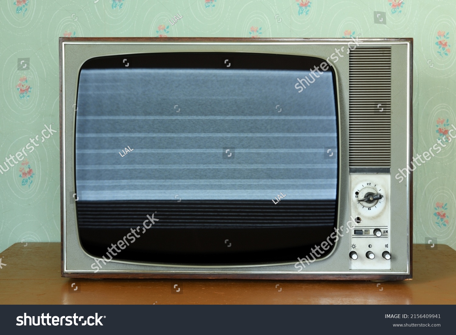 Old vintage TV with screen noise in a room with vintage wallpaper. Interior in the style of the 1960s. #2156409941