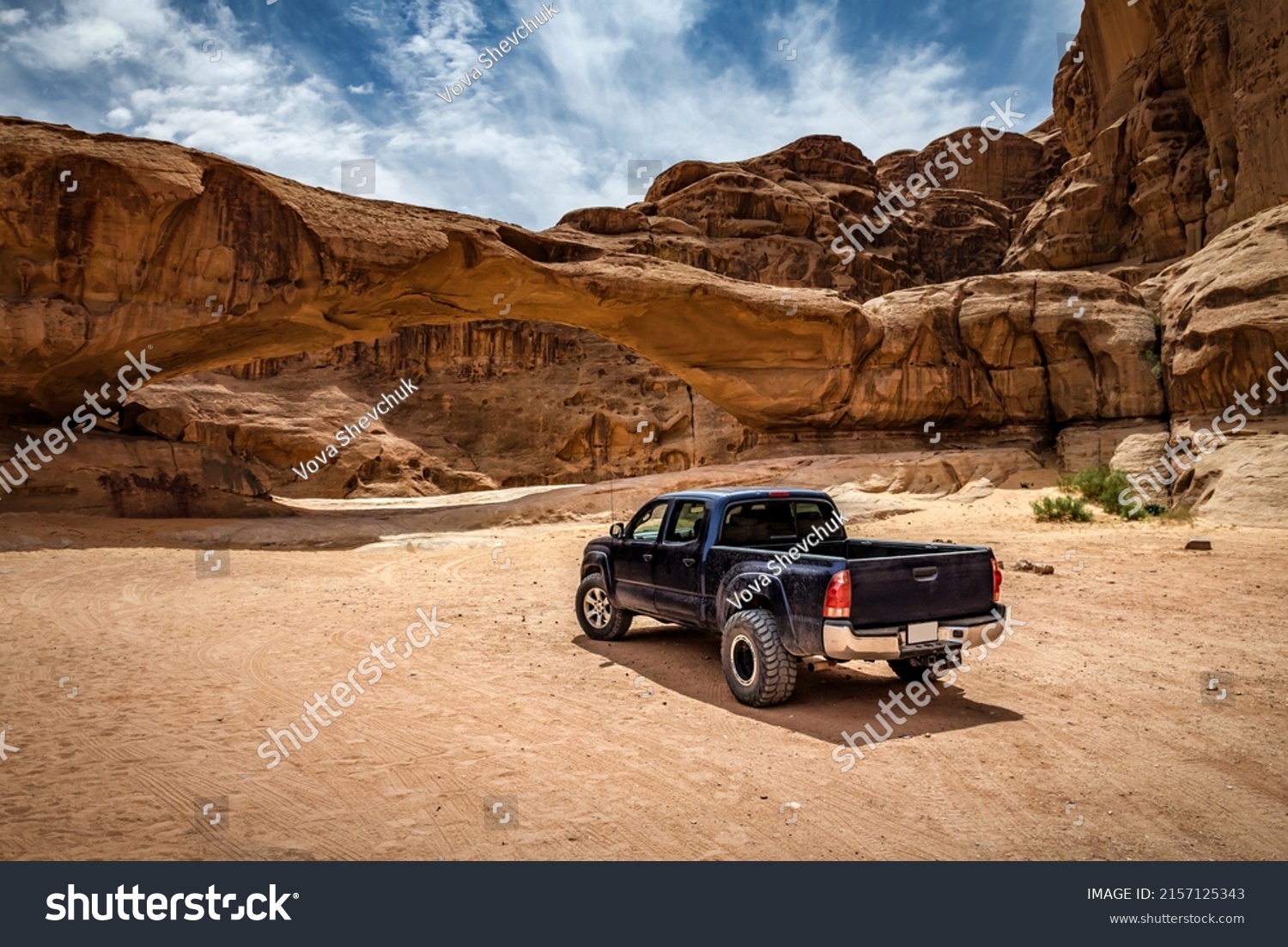 Off-road car near the rock arch in Wadi Rum desert. Jordan #2157125343