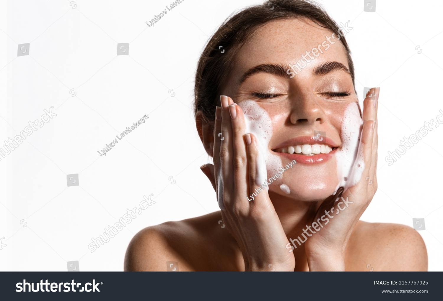 Portrait of cheerful laughing woman applying cleansing foam for washing face. Lovely brunette with attractive appearance. Skincare spa relax concept. Isolated on white background #2157757925