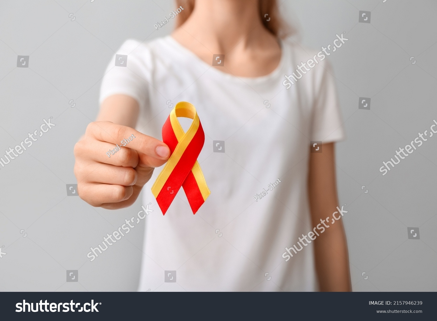 Woman in white t-shirt with awareness ribbon on grey background, closeup. Hepatitis concept #2157946239