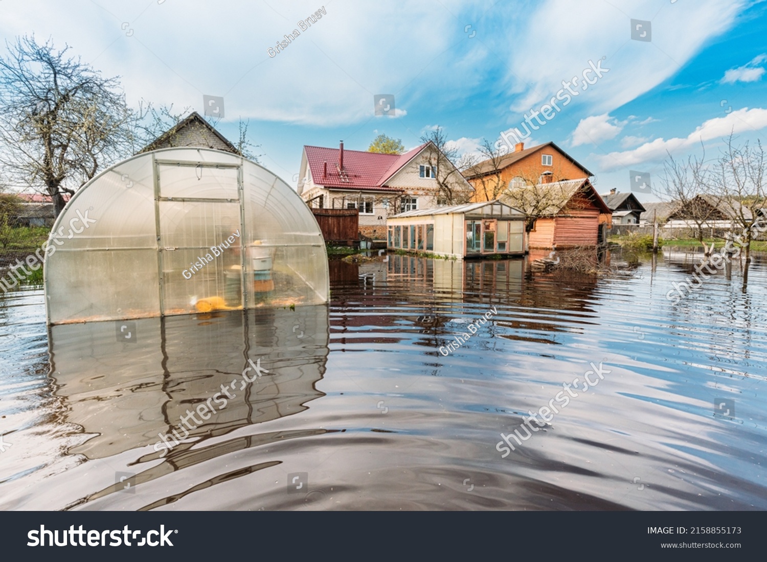 Vegetable Garden Beds In Water During Spring Flood floodwaters during natural disaster. Greenhouse Hothouse in Water deluge During A Spring Flood. inundation River. #2158855173