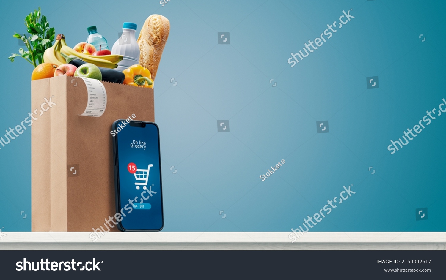 Grocery shopping app and grocery bag full of goods: online grocery shopping and home delivery concept, copy space #2159092617