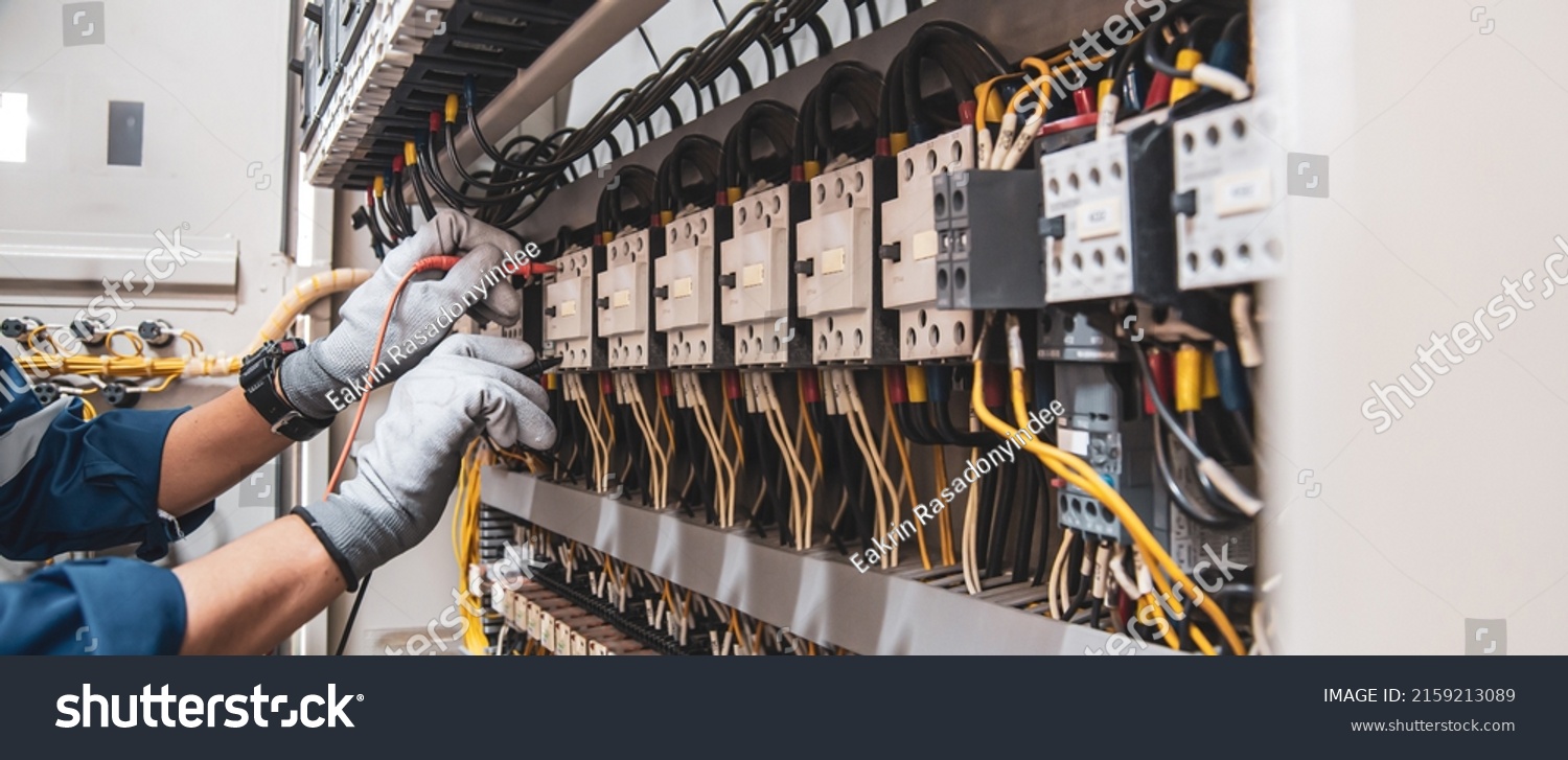 Electricity and electrical maintenance service, Engineer hand holding AC voltmeter checking electric current voltage at circuit breaker terminal and cable wiring main power distribution board. #2159213089