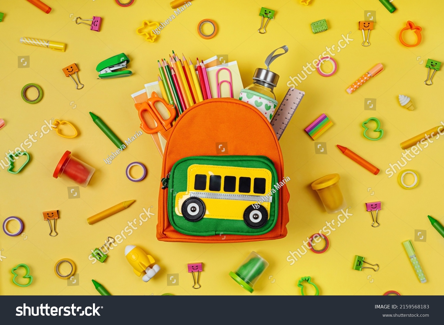 Kids Backpack with school bus on yellow background. Opened School backpack with stationery. Primary School or kindergarten.  #2159568183