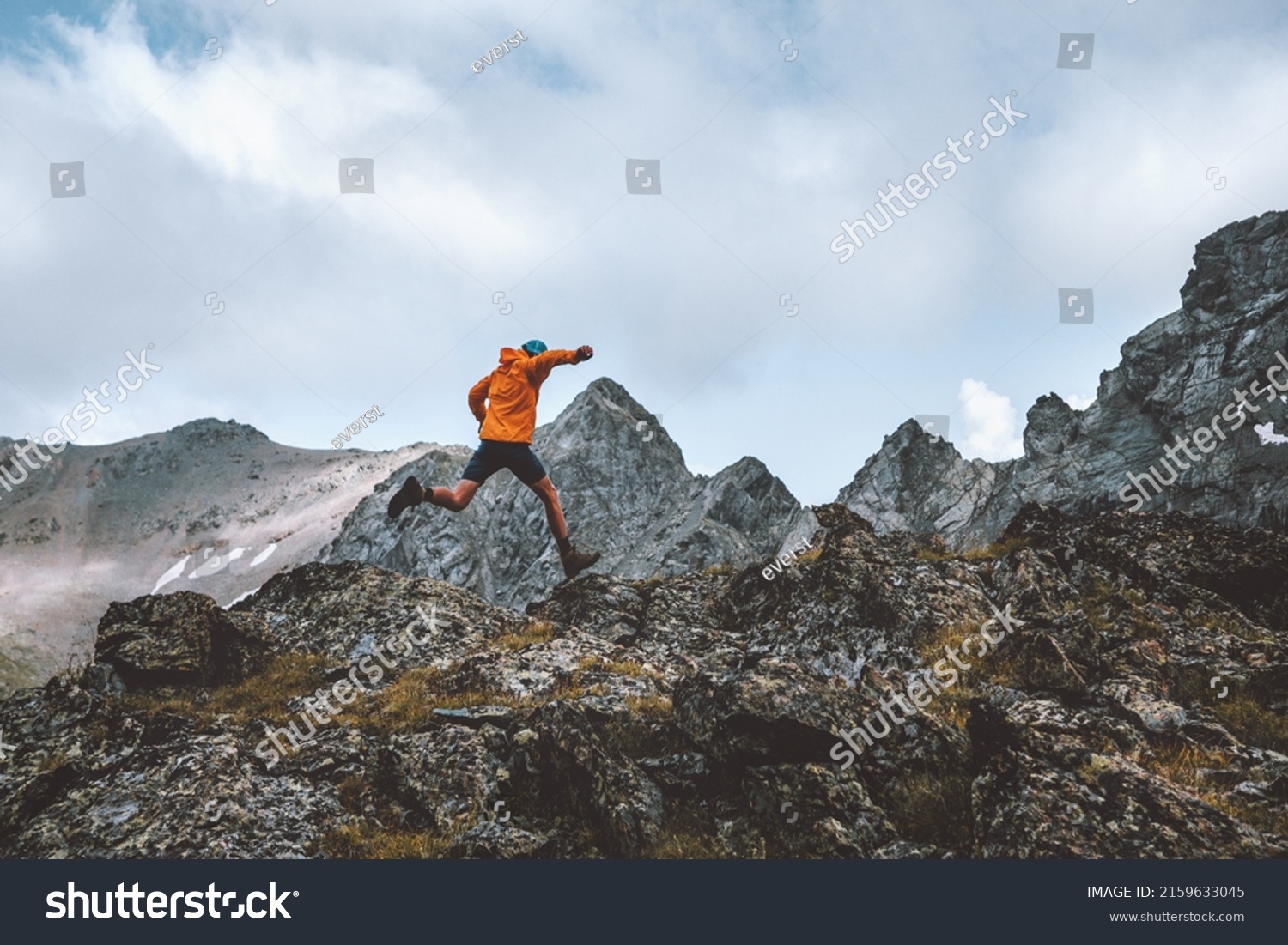 Man trail running in rocky mountains travel hiking adventure activity outdoor summer vacations healthy lifestyle skyrunning extreme sport concept #2159633045