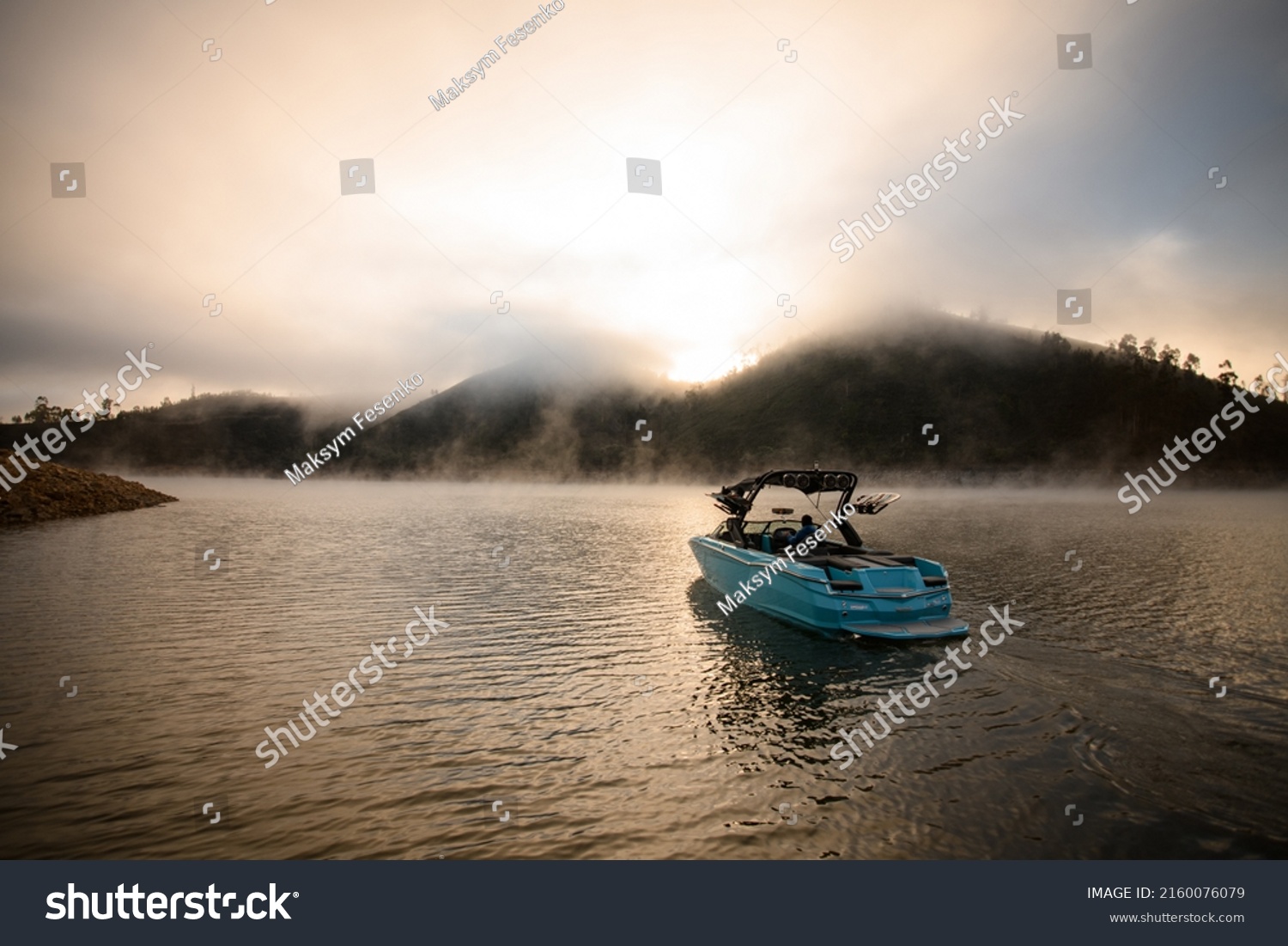 Great view on bright blue modern motor boat floating on water. Scenic view of hills and sky with cumulus clouds on the background #2160076079