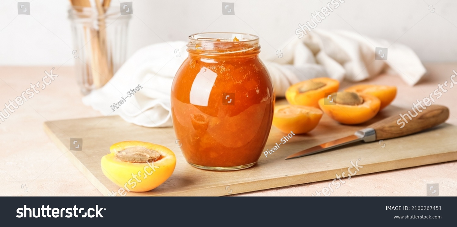 Jar of tasty apricot jam on table #2160267451