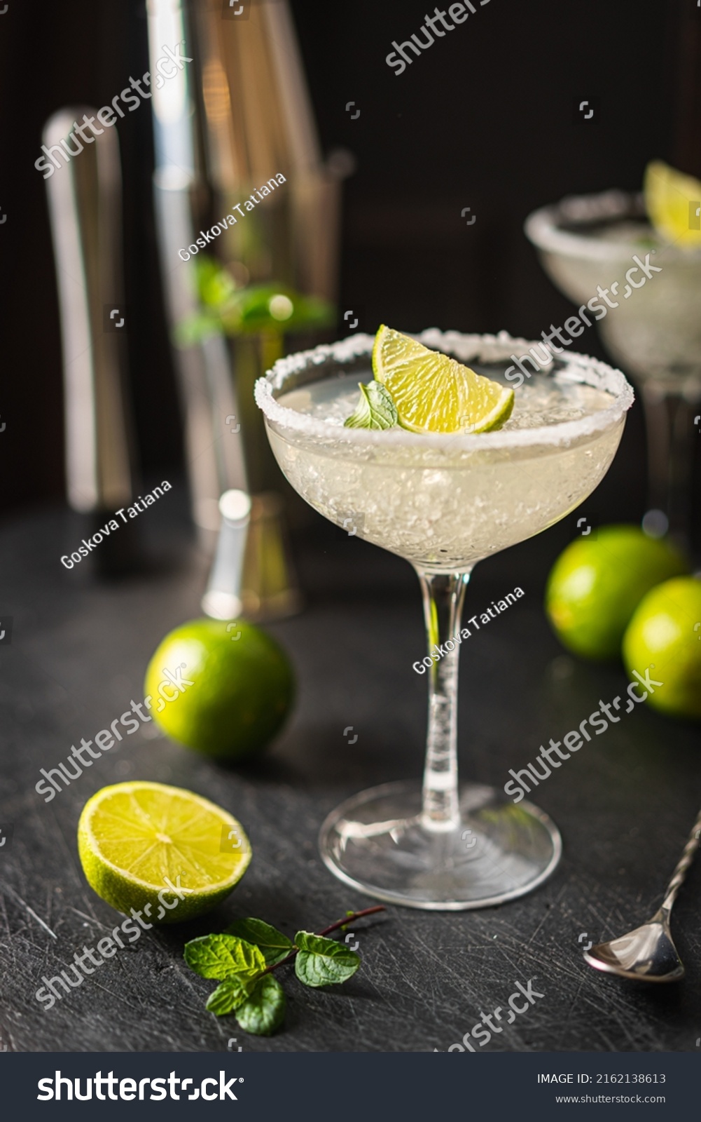 Margarita cocktail with lime and ice on dark wooden table with copy space. Classic Margarita and Daiquiri Cocktail. #2162138613