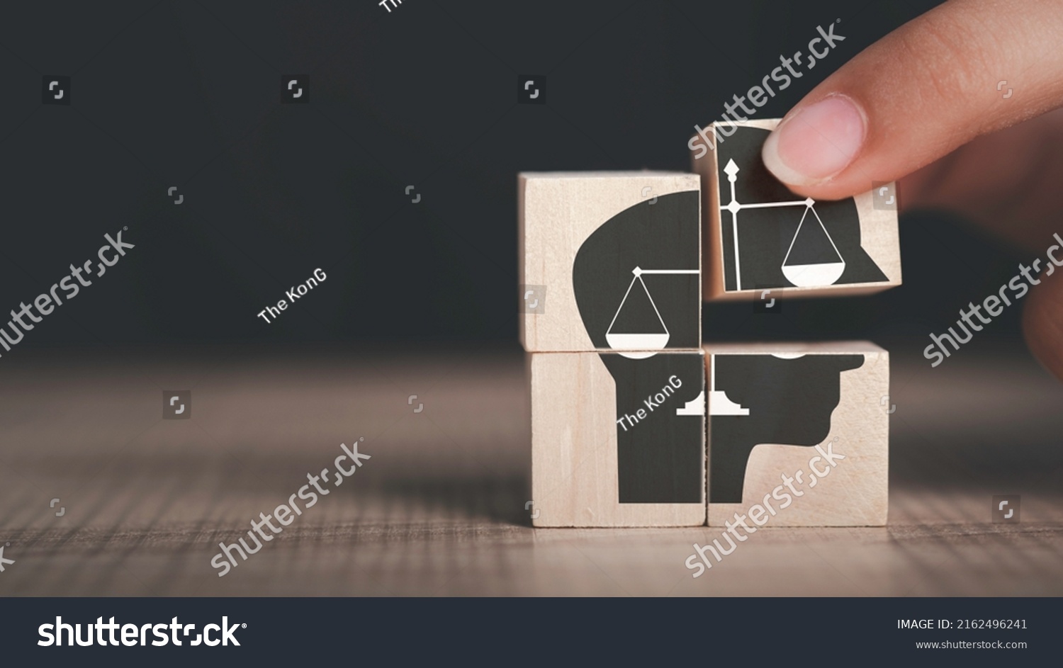 Ethics inside human mind, Business ethics concept. Hand hold ethics inside a head symbols in wooden cubes on dark background with copy space. #2162496241